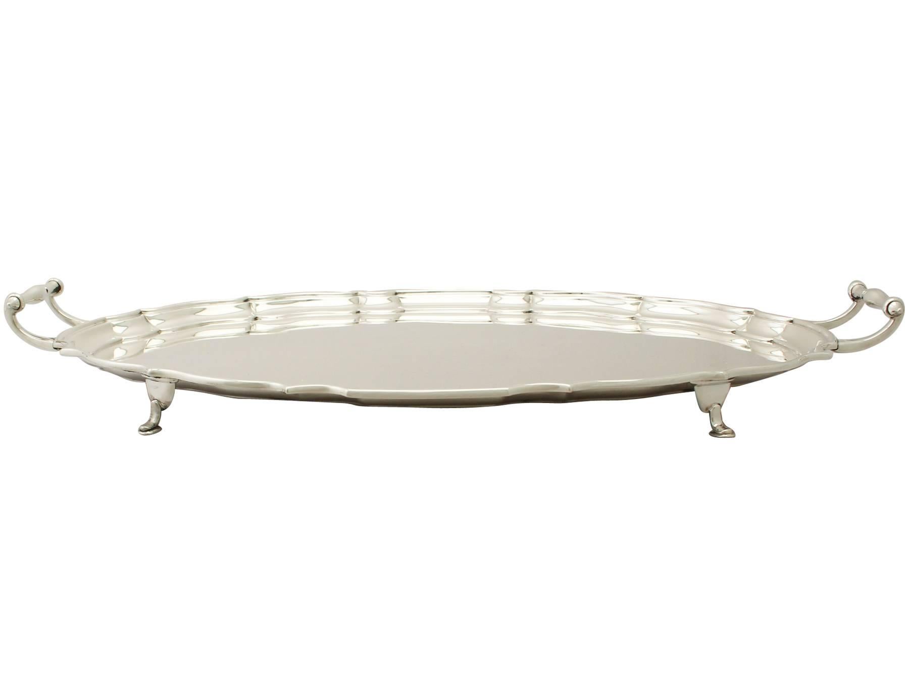 An exceptional, fine and impressive antique George V English sterling silver two-handled tea/drinks tray; an addition to our ornamental silverware collection.

This exceptional antique George V sterling silver drinks tray has a shaped oval