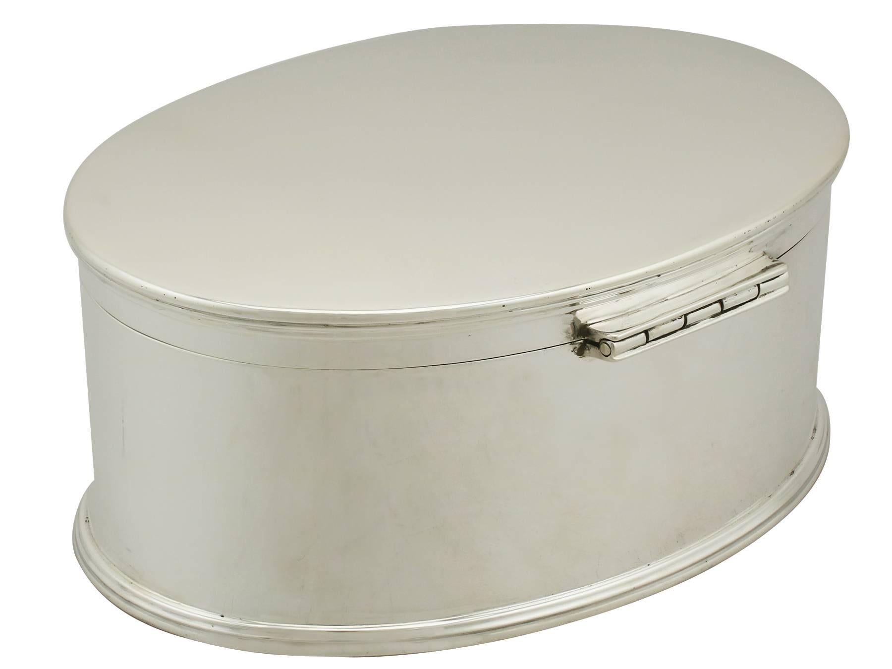 An exceptional, fine and impressive antique George V English sterling silver biscuit box; an addition to our silver teaware collection.

This exceptional antique George V sterling silver biscuit box has a plain oval form to a spreading