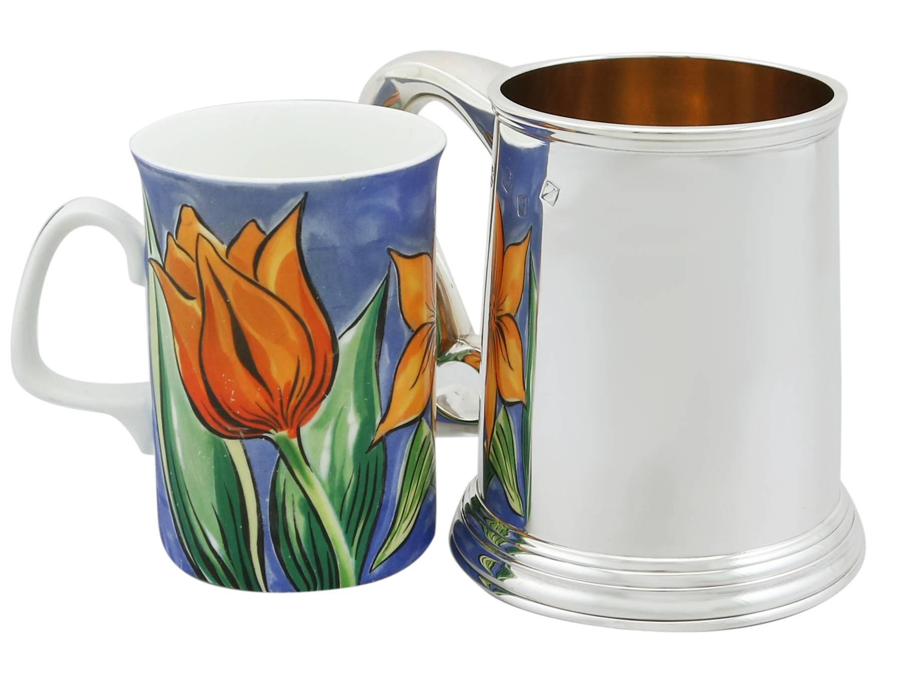 An exceptional, fine and impressive, vintage Elizabeth II Irish sterling silver pint mug; an addition to our silver dining collection.

This exceptional vintage Elizabeth II Irish sterling silver pint mug has a plain tapering cylindrical form to a