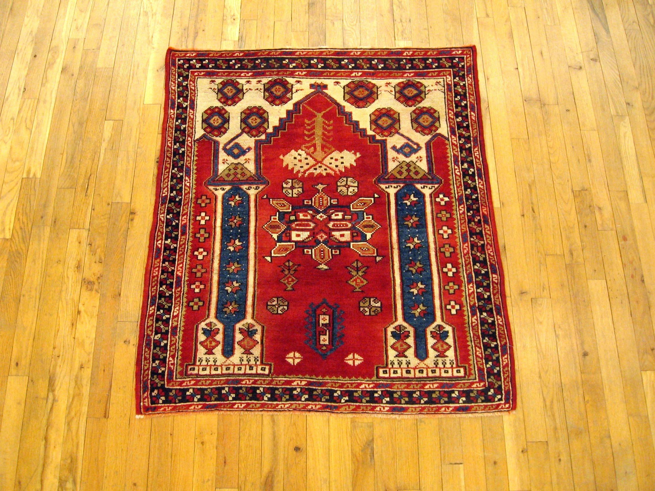 An antique Turkish Bergamo oriental rug, size 3'10 H x 3'3 W, circa 1900. This handsome hand-knotted wool rug features a red central field with a Directional design, characterized by two stately pillars leading to a softly colored arch at top and