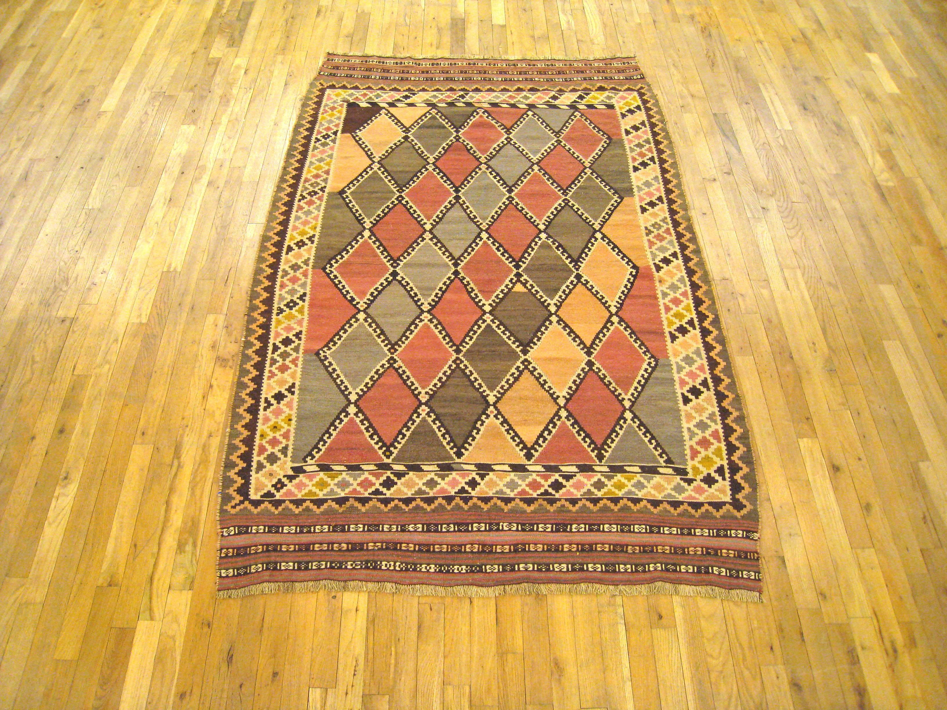 An antique Persian Kilim with Ghasghai diamond design, size 7'0 H x 4'6 H, wool flat-weave in small size, circa 1920. This delightful handwoven Persian Kilim rug is flat-woven, with no upward pile. It features a stylish Ghashgai diamond design, with