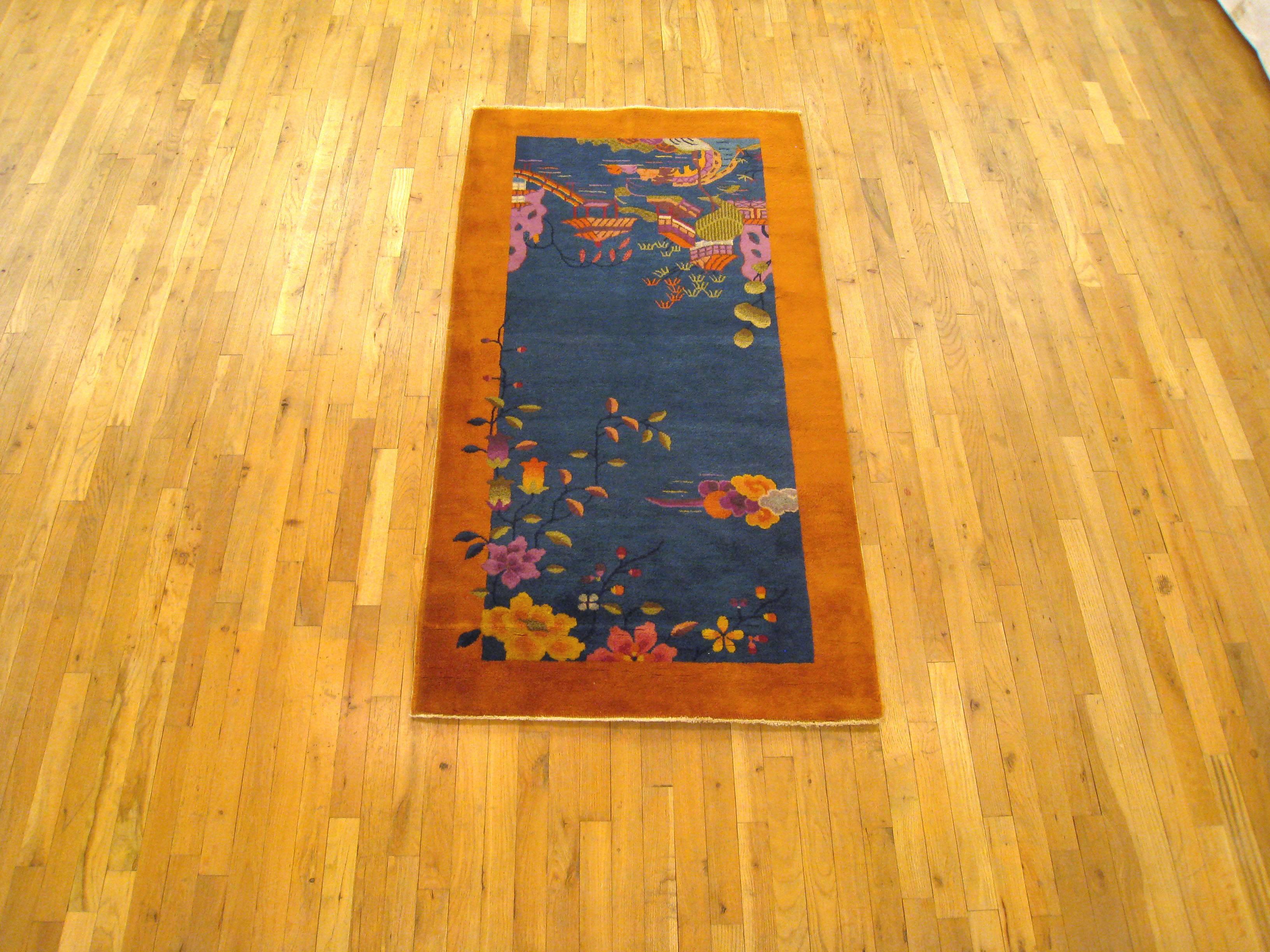 An antique Chinese Art Deco oriental rug, size 6'0 x 3'0, circa 1920. This lovely hand-knotted antique carpet features a distinctive color palette, with blues in the directional central field, and a unique gold color in the outer border. The field