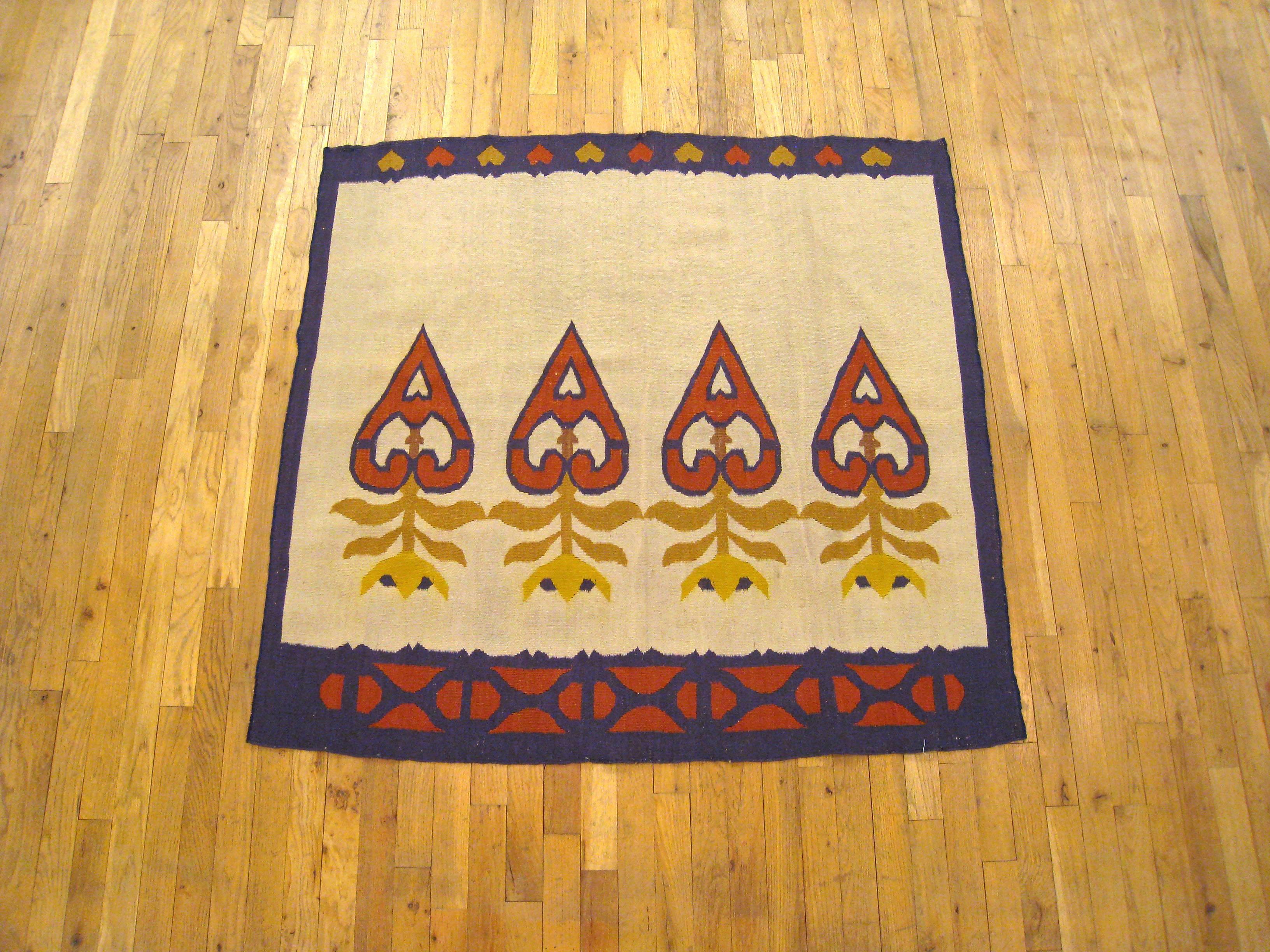 A vintage Turkish Kilim oriental rug, size 4' x 4', circa 1940. This hand-knotted, flat-woven decorative carpet features a rarely found ivory ground in the central field, highlighted by four stylized flowers. The central frame is enclosed within a