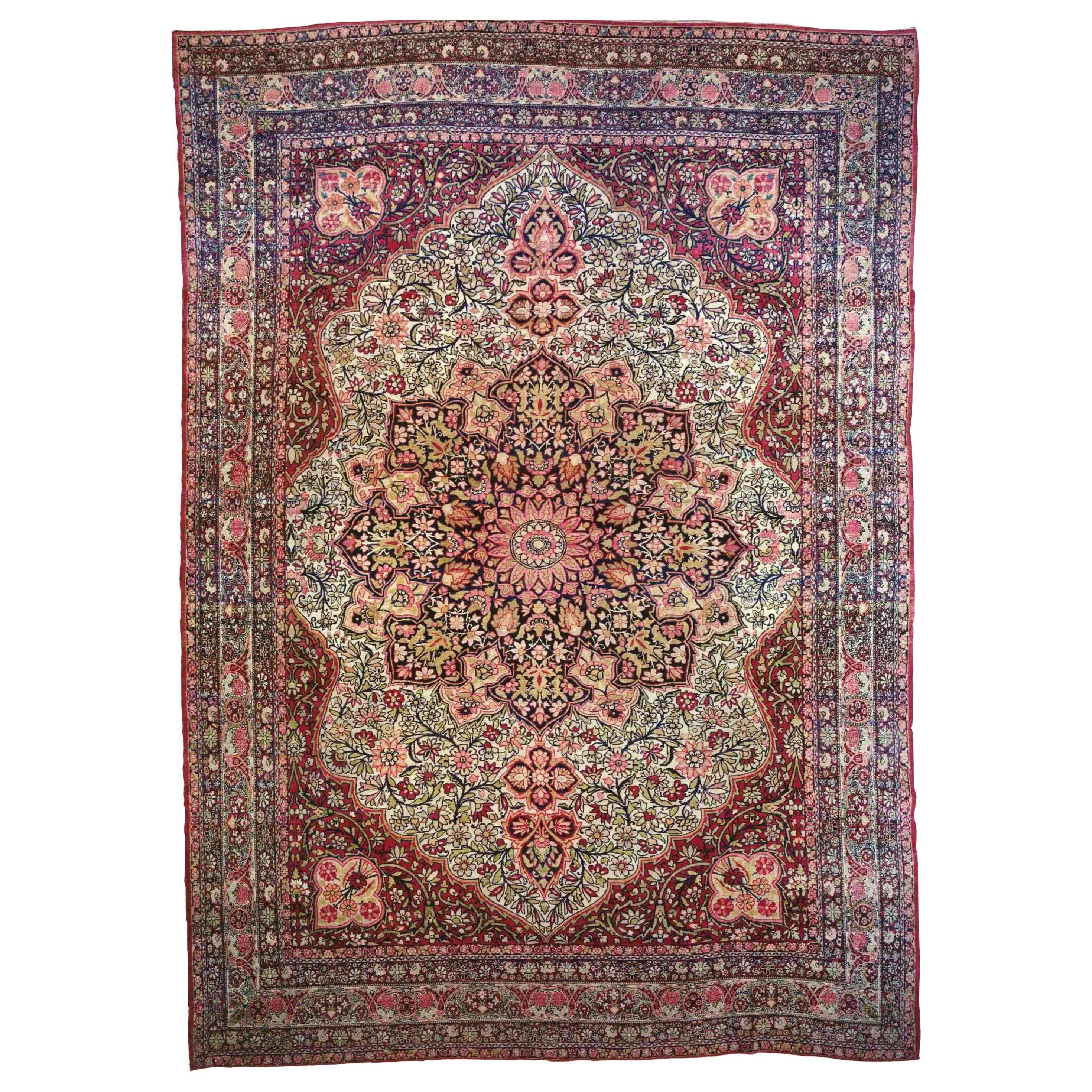 An antique Persian Lavar Kerman carpet, circa 1890, size 13'4 x 9'4.  This lovely hand-knotted wool carpet features a very fine weave, with short pile, and a beautiful medallion design.  The intricate medallion is in a star shape at the center of