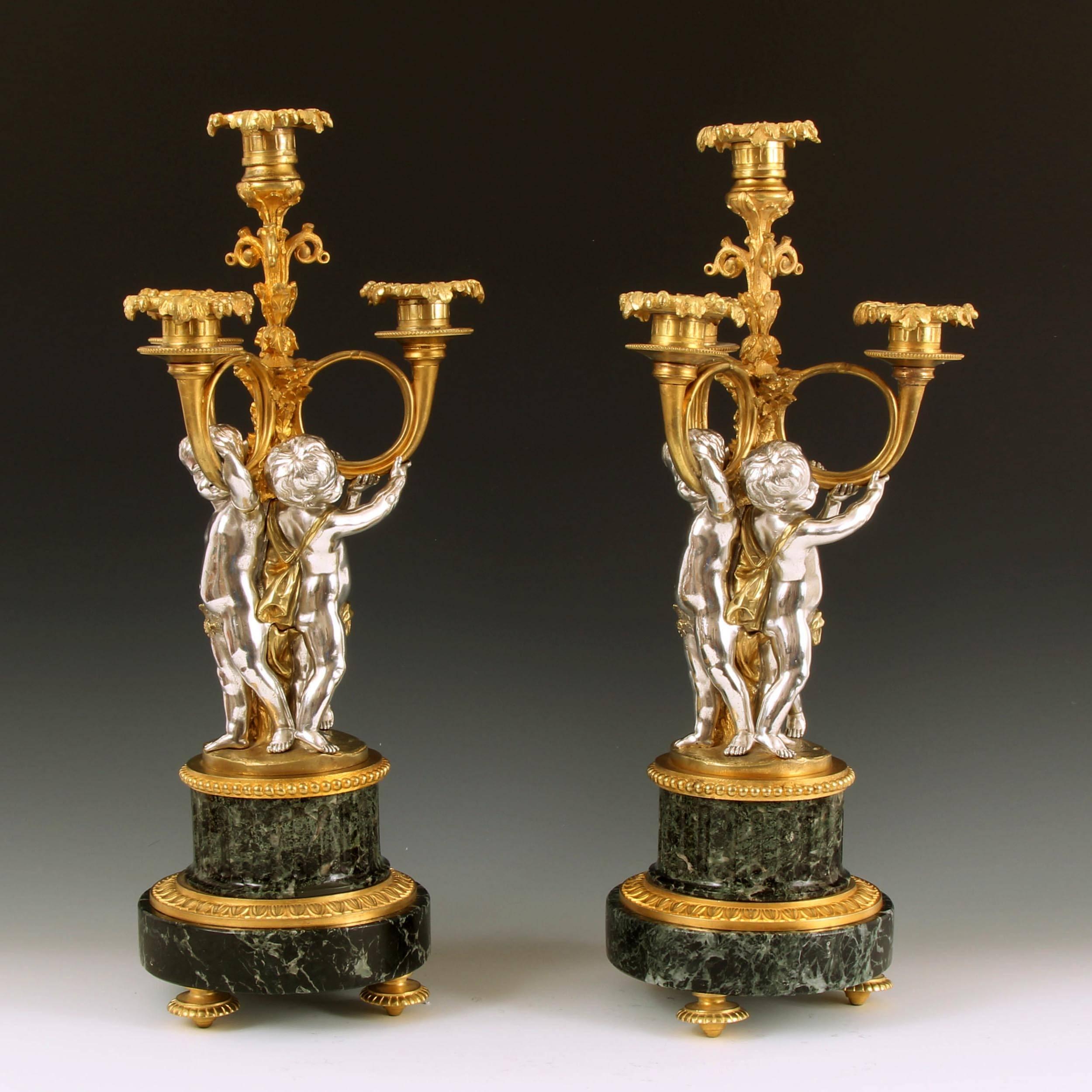 A fine pair of four-light gilt bronze candelabra each supported by three finely modelled silvered putti, standing on verde antico stepped marble bases. Each candelabra stamped with the makers mark VP beneath a crown. 

Victor Paillard (1805-1886),