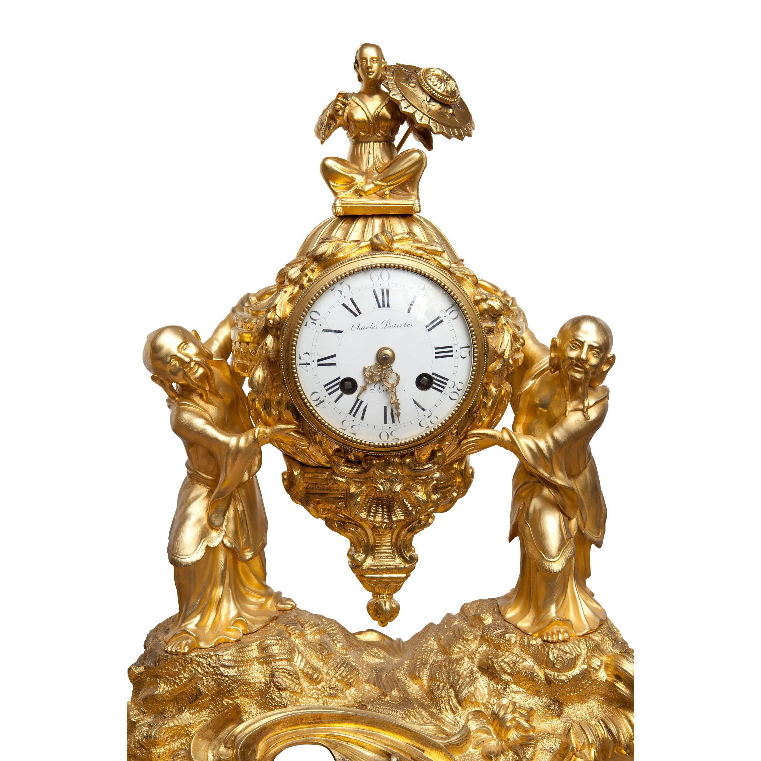 A fine chinoiserie orientalist gilt ormolu three-piece Louis XV 18th century clock garniture, the central clock supported by Chinese men in robes standing on a rocky base, the clock flanked by two gilt ormolu candelabra, again supported by Chinese