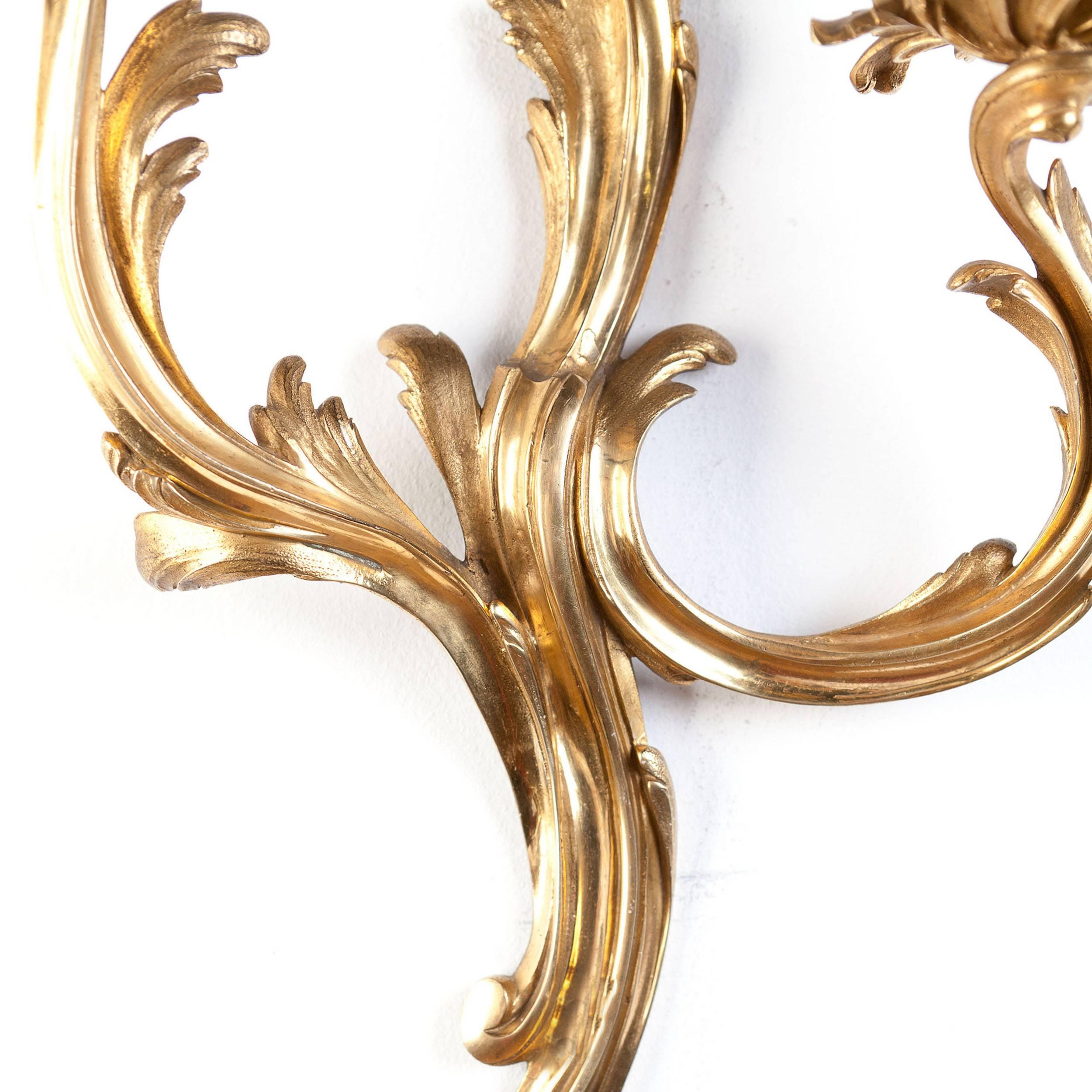 Of superb quality, this pair of rare mid-18th century Louis XV gilt ormolu wall appliqués cast in bronze with superb detailing. Each with two Rococo arms of sinuous design and of exceptional proportion. 

This design is very much in the manner of