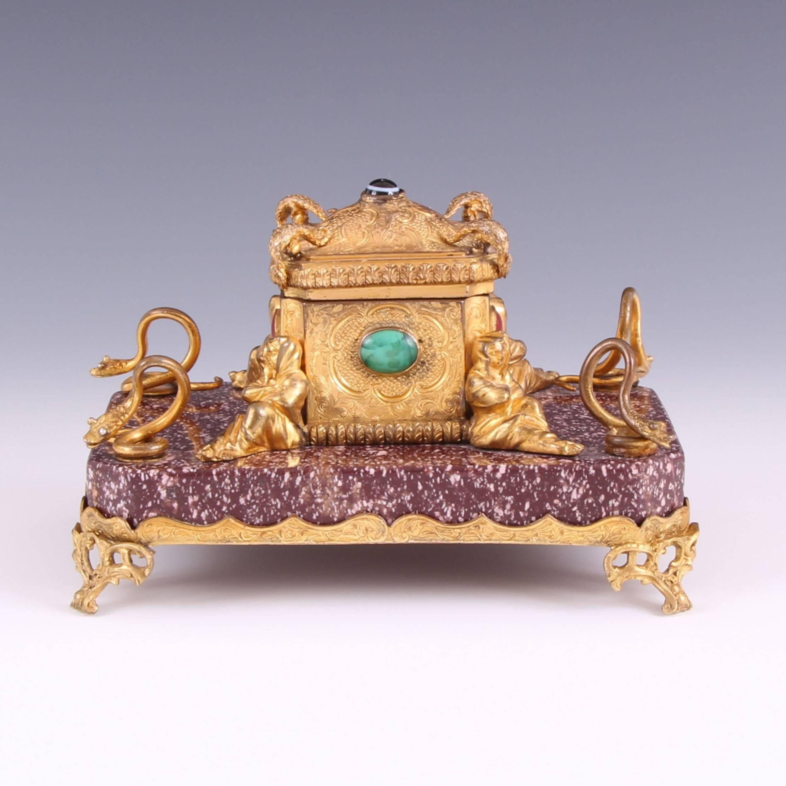 Of exceptional quality, being in the form of a casket set with five oval shaped semi-precious cabochon stones, sitting on the finest ancient Egyptian Porphyry. The attention to detail is incredible, the four corners of the lid are surmounted with