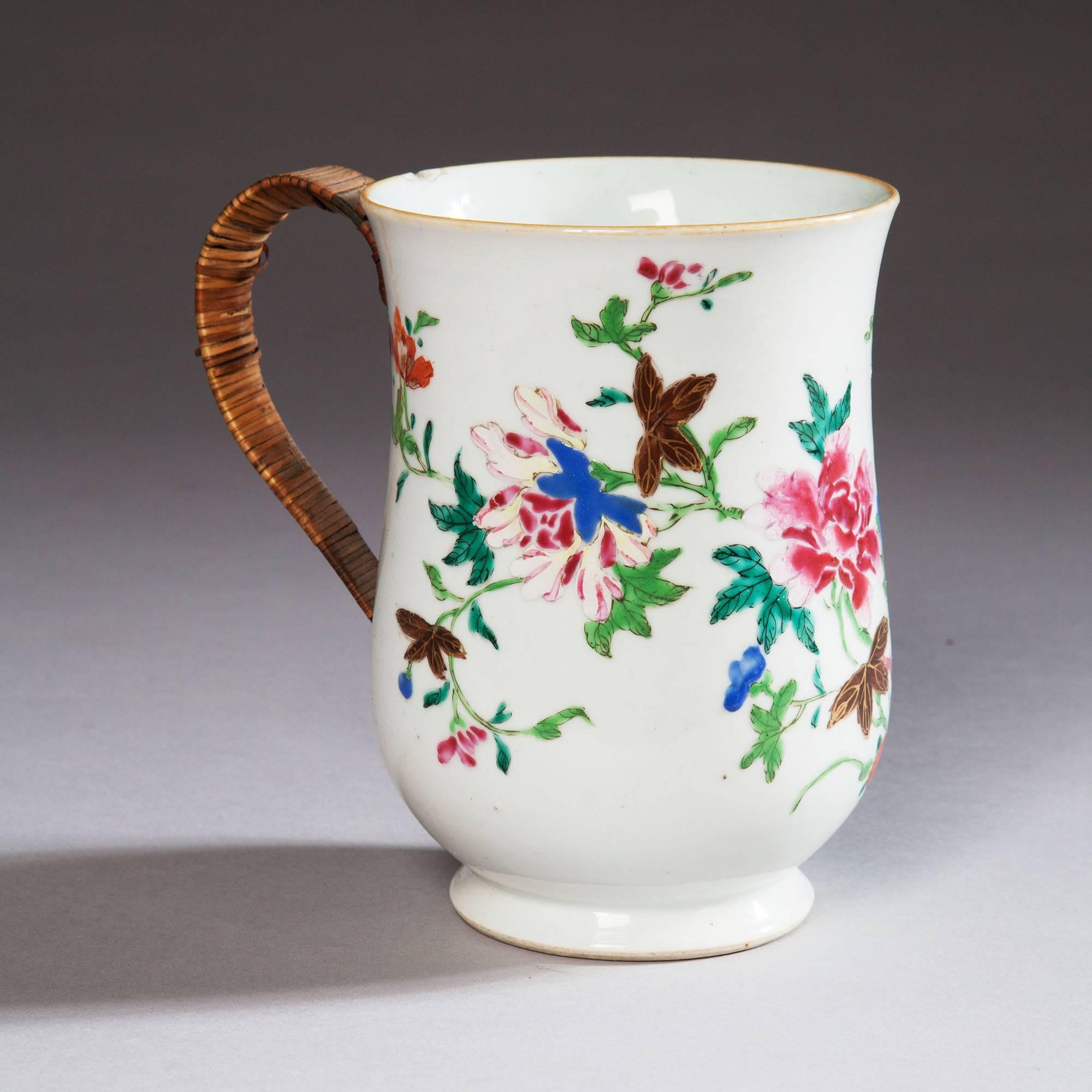 A Chinese export famille rose tankard having a straw weave replacement handle and decorated with rocks and flowers of bold design.
China, circa 1750.
Measures: Height 8 in (20 cms).