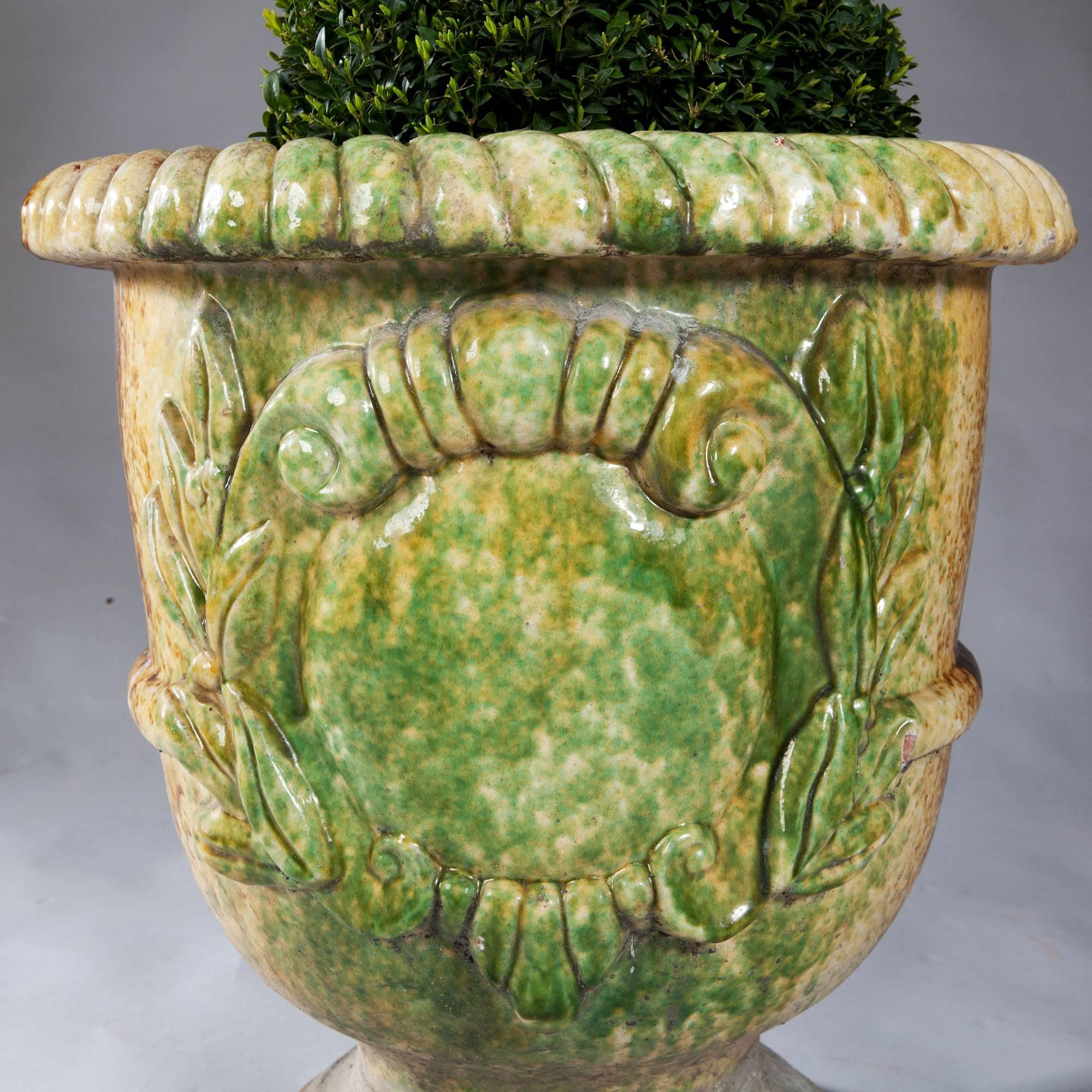 Of large scale: A pair of glazed terracotta pots, with mottled greens, yellows and browns, the front with a blank shield.

Both missing banding on the reverse. See photos.

Internal diameter 17.5 inches.