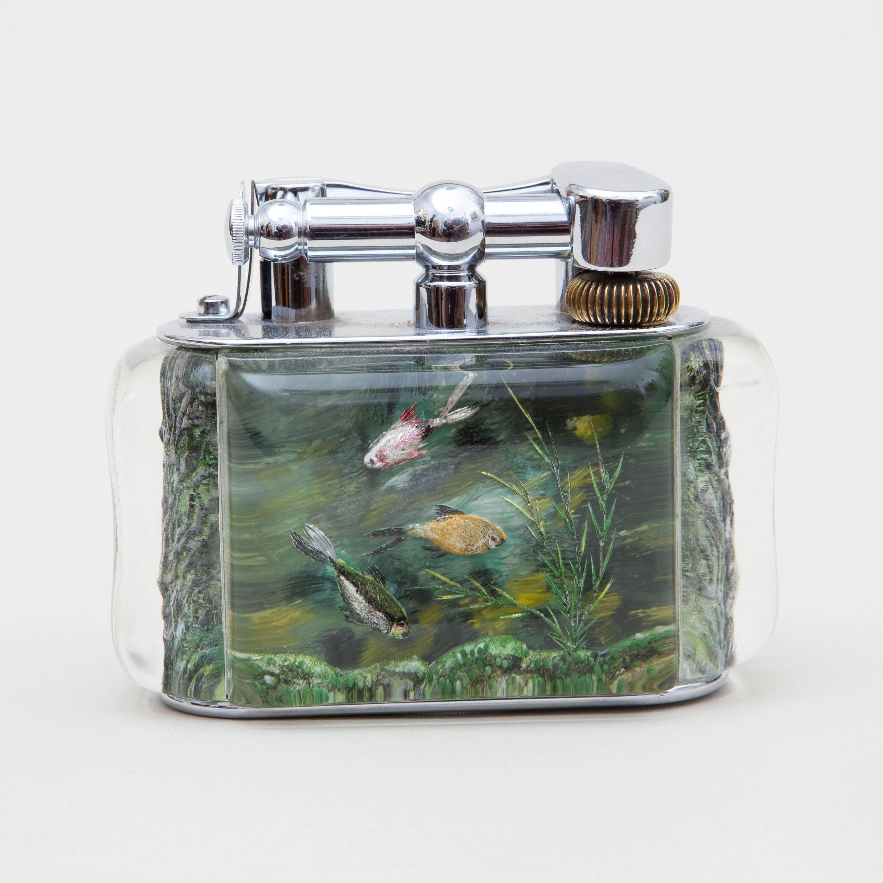 England, circa 1950.
​
A rare mid-20th century early Dunhill 'Aquarium' table lighter, the chrome body with sprung lift arm with Dunhill in high relief. With four panels of engraved Lucite forming two distinct scenes separated by the end panels.