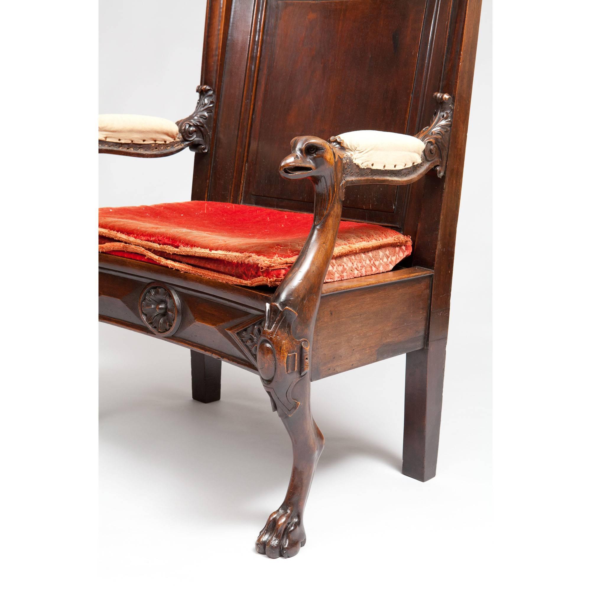 A substantial walnut throne chair, the curved back with arms terminating in eagle heads, the whole raised on zoomorphic legs terminating in lions paws.

Measures: H 41.5,
W 30,
depth of seat 17,
height of seat 19 including cushion.