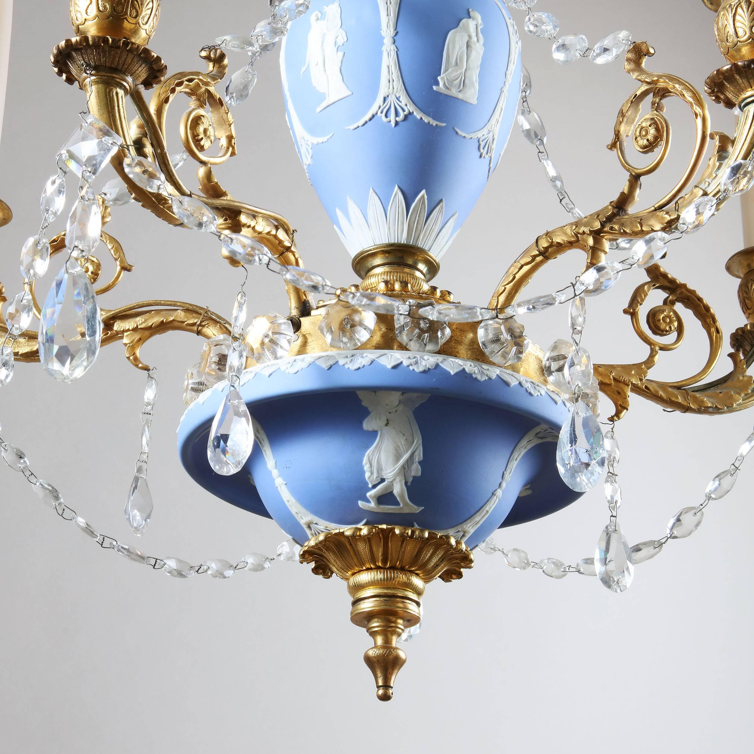 A rare early 19th century Regency period English chandelier, the body of Wedgwood jasperware mounted with elaborate gilt ormolu metal work issuing five electrified candle arms and hung with crystal drops.