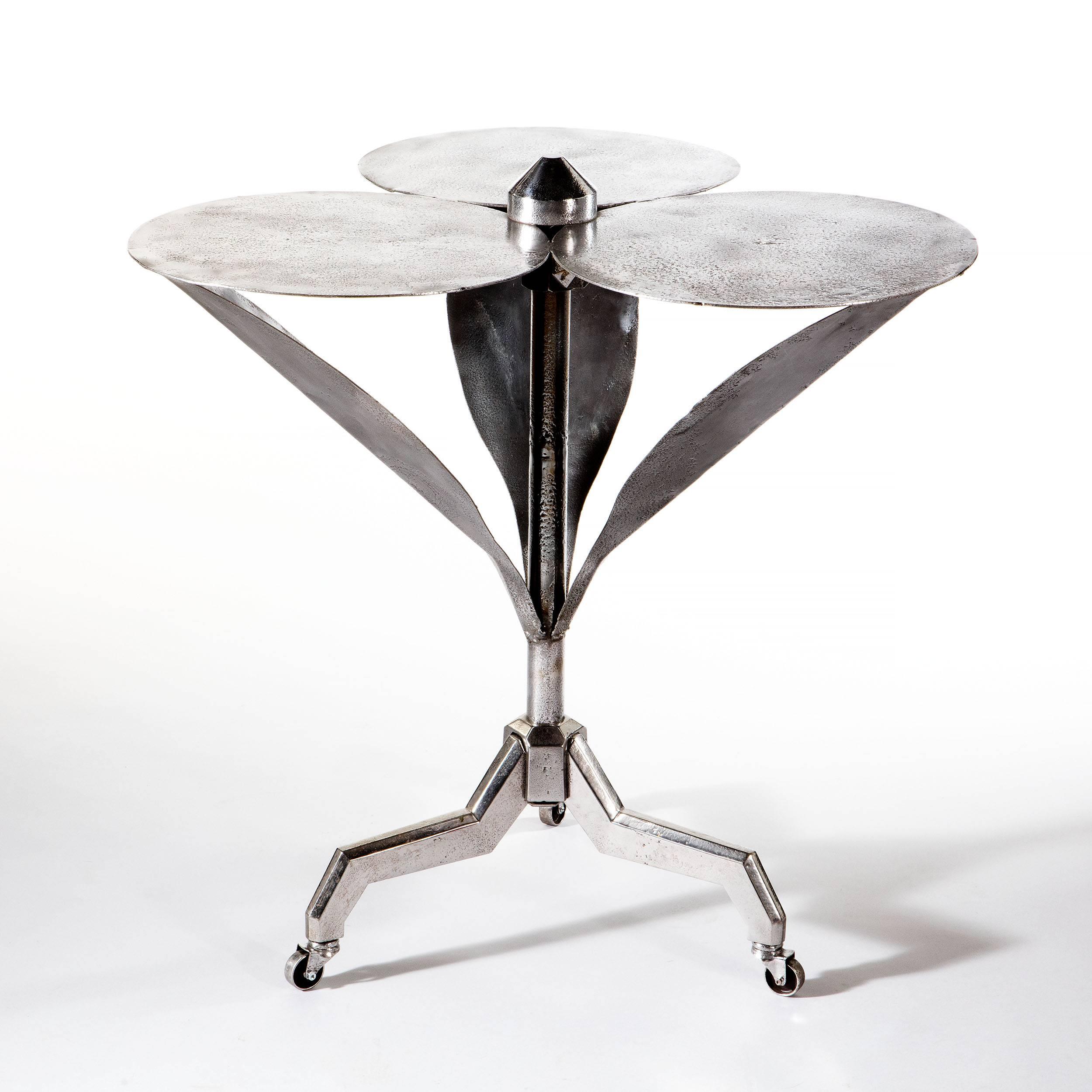 Gueridon-Beistelltisch aus hochglanzpoliertem Stahl mit den glänzenden Stahlblättern und Blütenblättern einer Blume.

Dieser Tisch stammt aus dem frühen 20. Jahrhundert, aus der Zeit des Art déco, und wurde wahrscheinlich in Frankreich hergestellt.