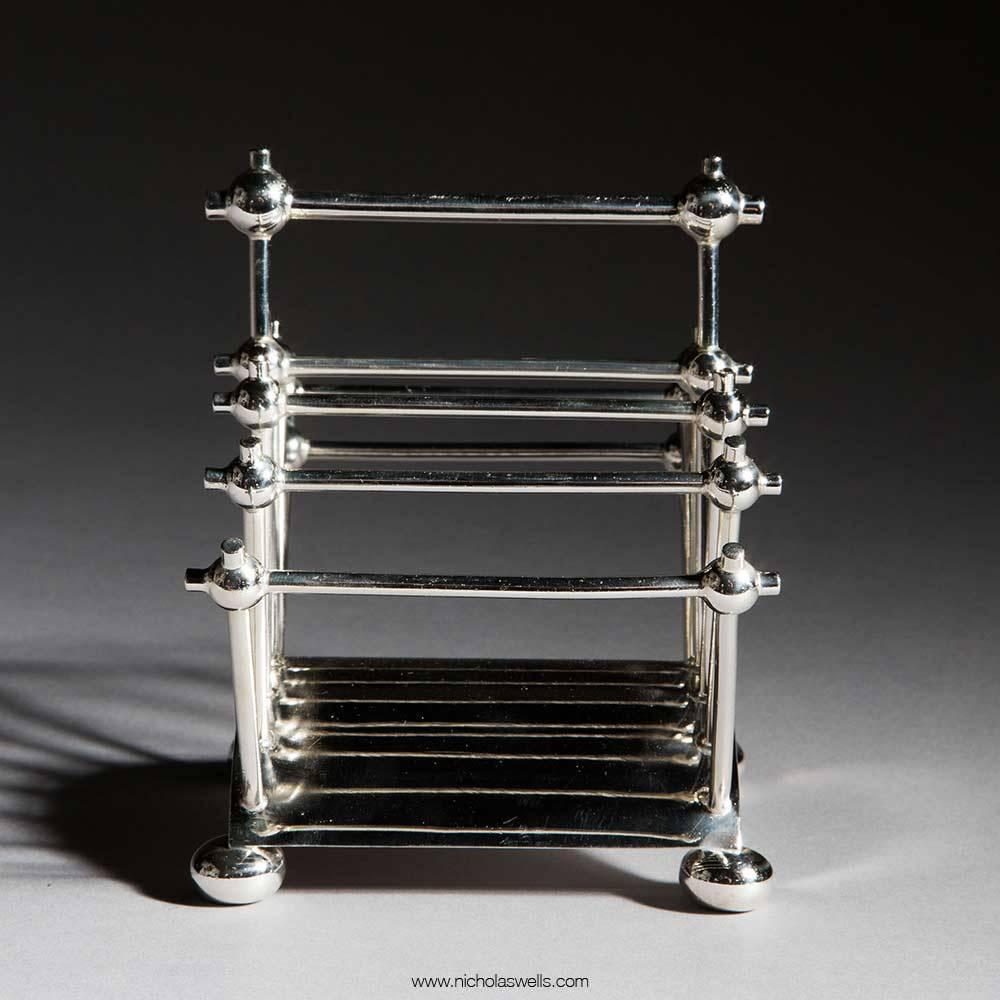 Letter rack designed by Dr Christopher Dresser, model no.2556, and made by Hukin & Heath, of rod and ball construction on arched base, raised on bun feet, the underside with stamped marks.

Measures: ​12.5cm. high.
​
Literature:
Dr Christopher