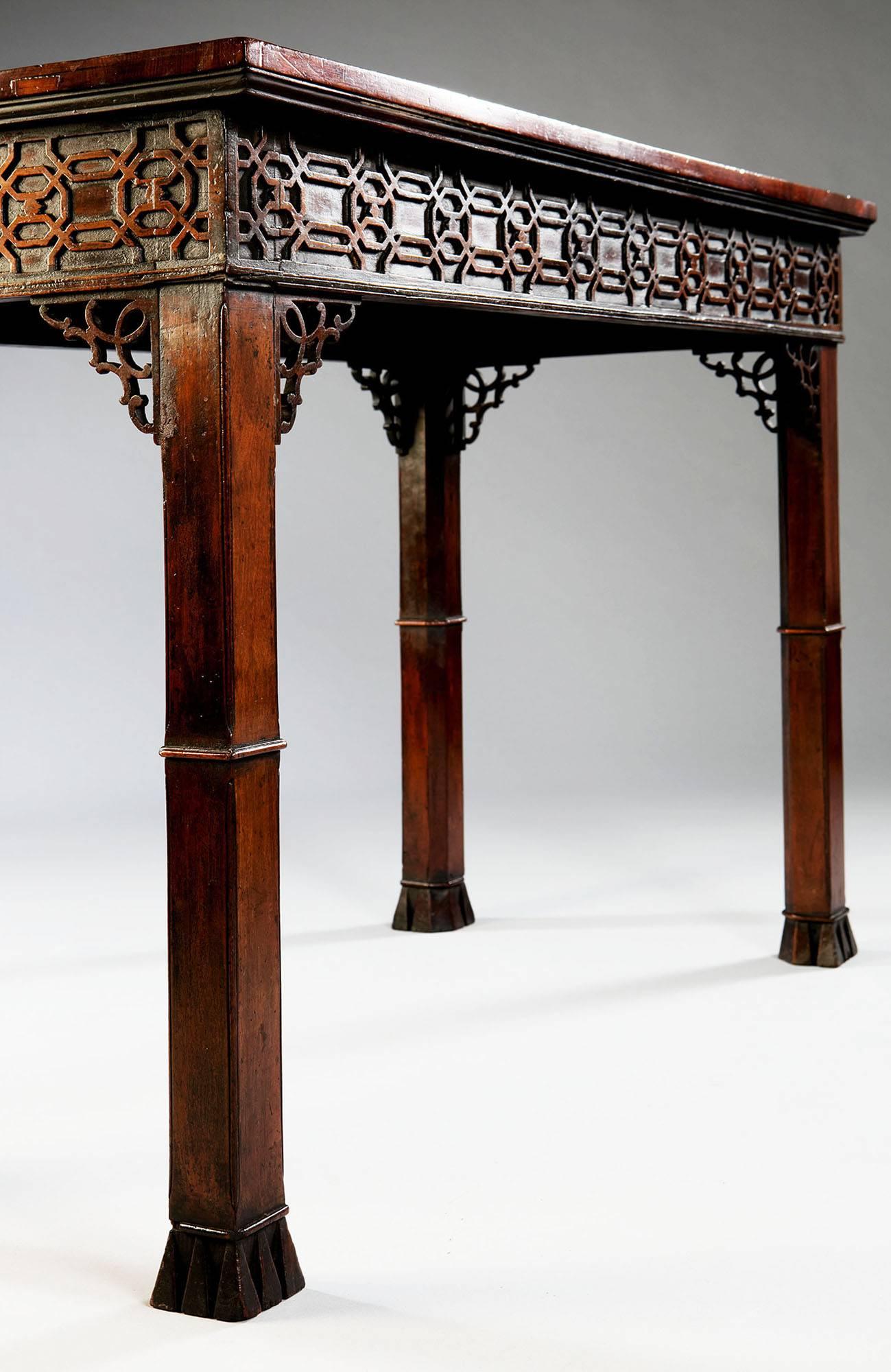 England, circa 1770 A fine 18th-century mahogany centre table, the later marble top above a chinoiserie blind fretwork frieze finished on all sides and raised on square chamfered legs with pierced spandrels and fabulous geometric block feet made up
