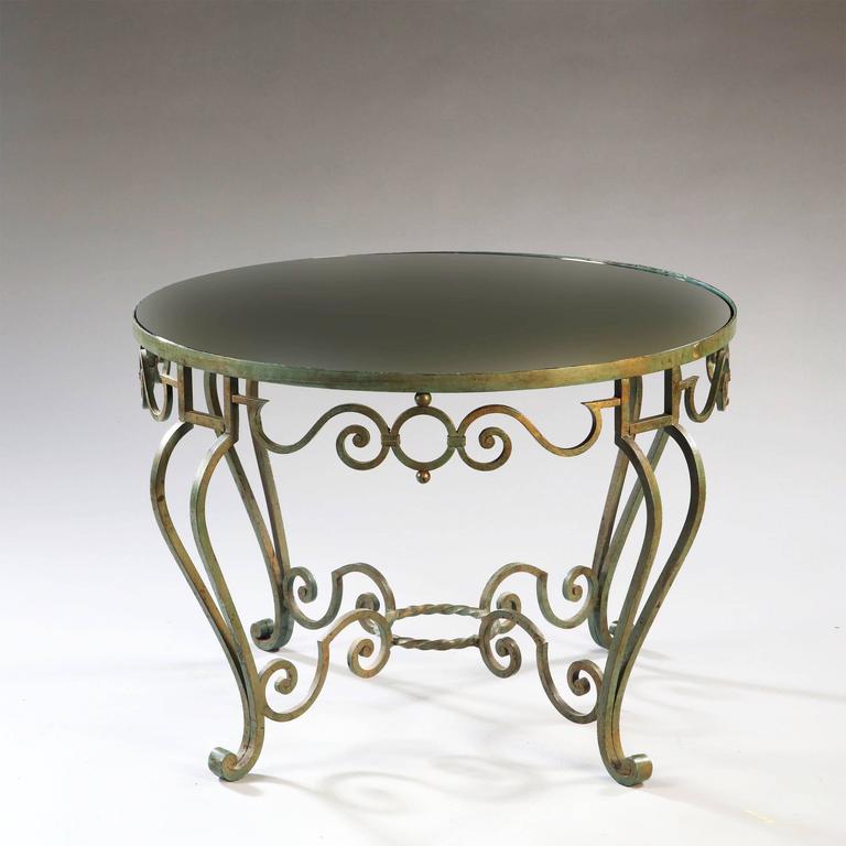 A small-scale French 1940s wrought iron circular low table, having an elaborate scrolling frieze and stretcher, all decorated with a green lacquer with gilt wash enrichment.

France, circa 1945.

The design derives from the oeuvre of Rene Prou