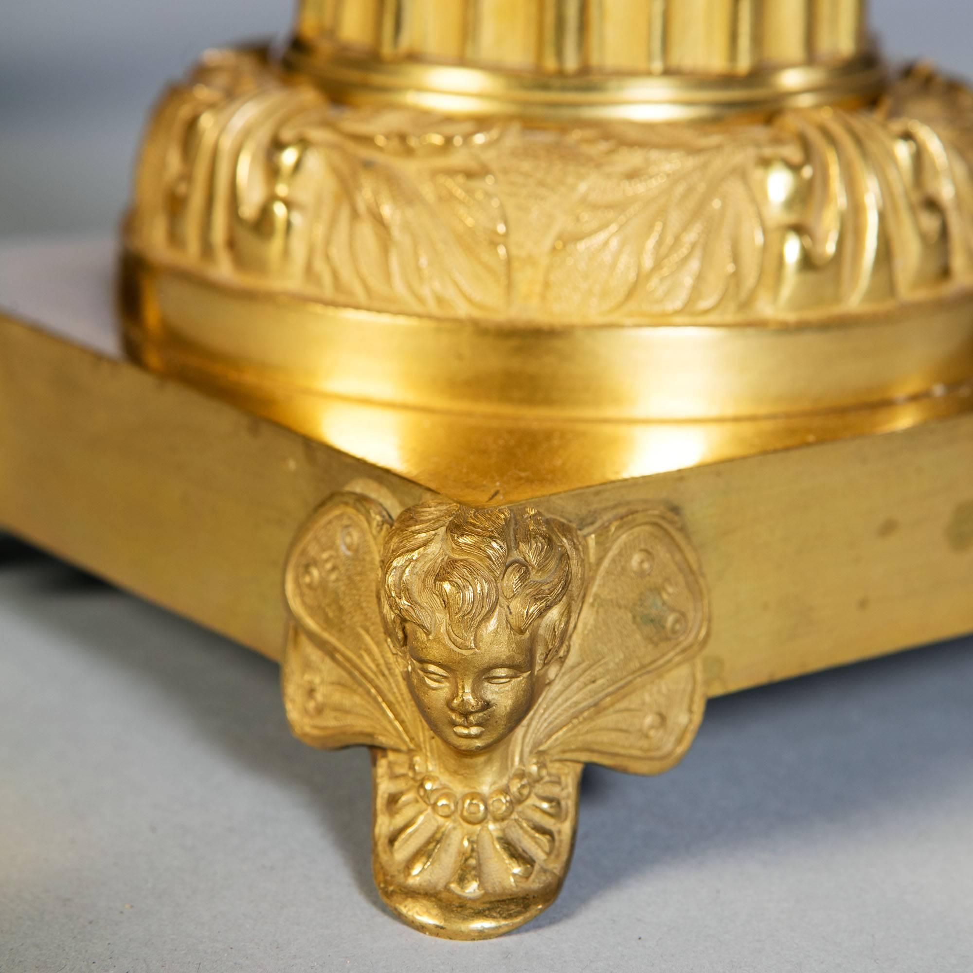 Paire de très belles lampes de table en bronze doré et tole du XIXe siècle, reposant sur des bases carrées soutenues par des cupidons ailés, la colonne cannelée effilée avec des reflets dorés brunis sur une monture circulaire échelonnée en bronze
