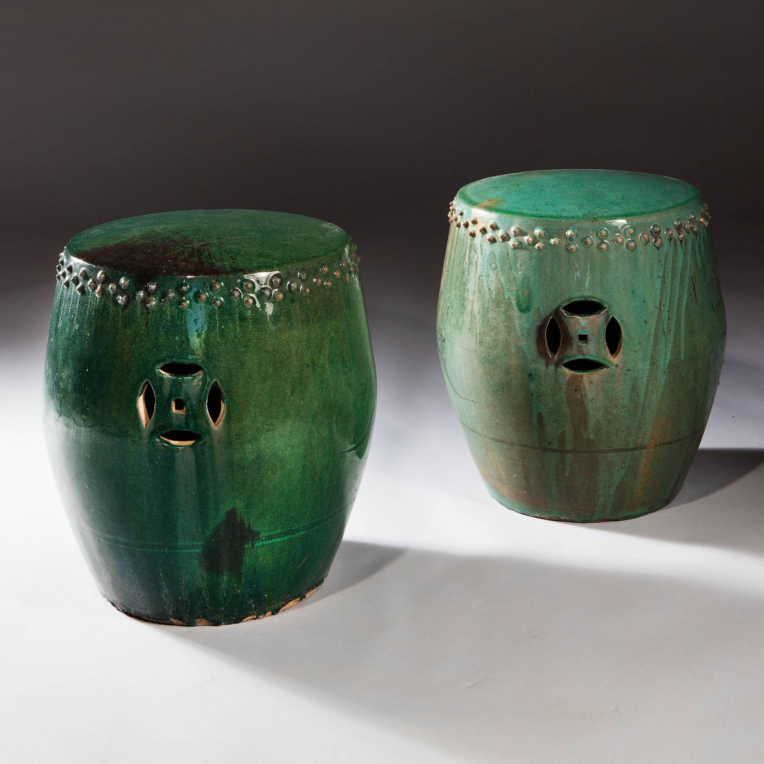 A highly decorative pair of vibrant green glazed Chinese pottery stools, the slightly domed seats above a frieze of points, pierced geometric motifs in the sides and a small floral detail. 

Measures: Height 16.5in, 42cm 
Diameter 14in, 35.5cm.