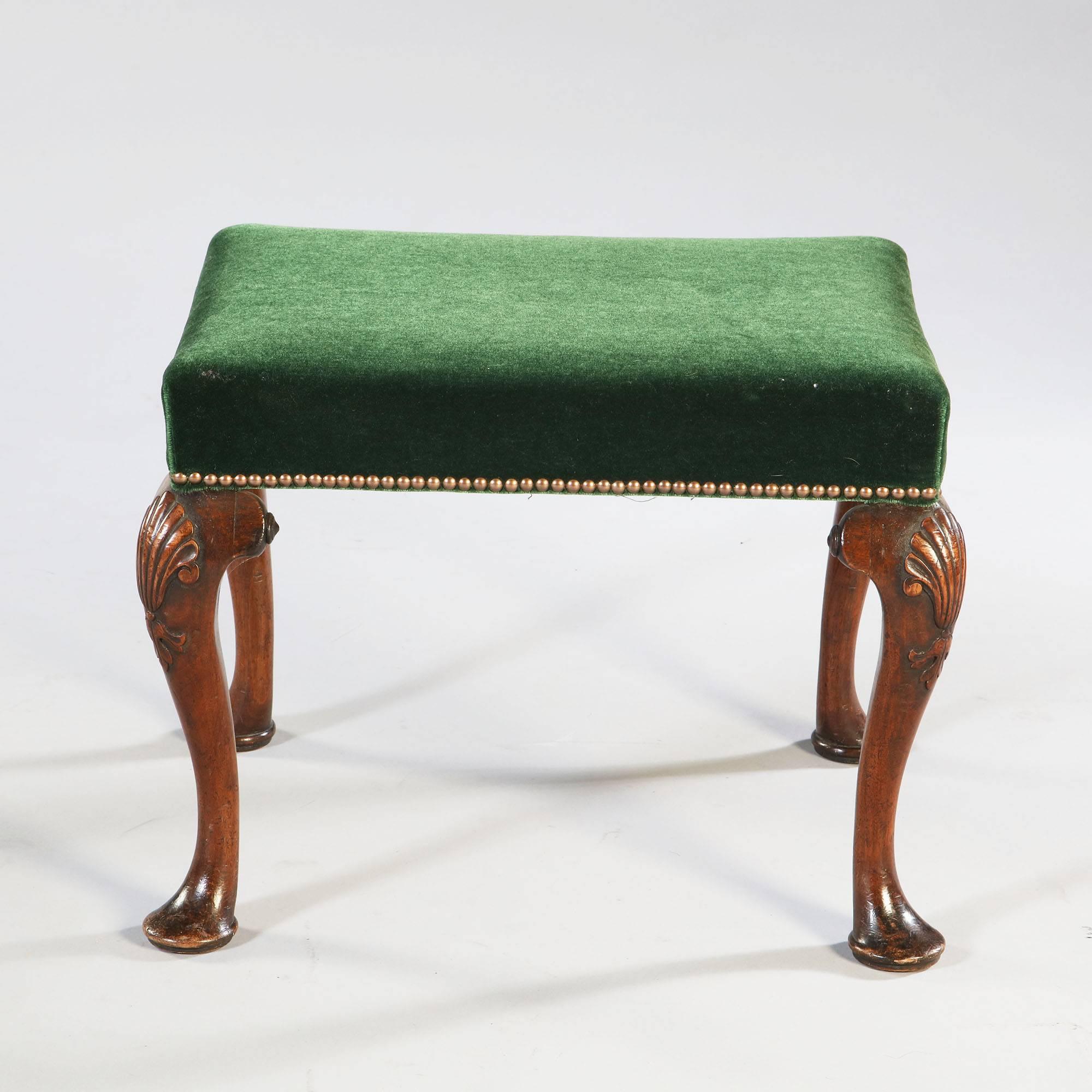 A fine early 18th century walnut stool with cabriole legs with carved shells and terminating in pad feet. Now upholstered in a green velvet.