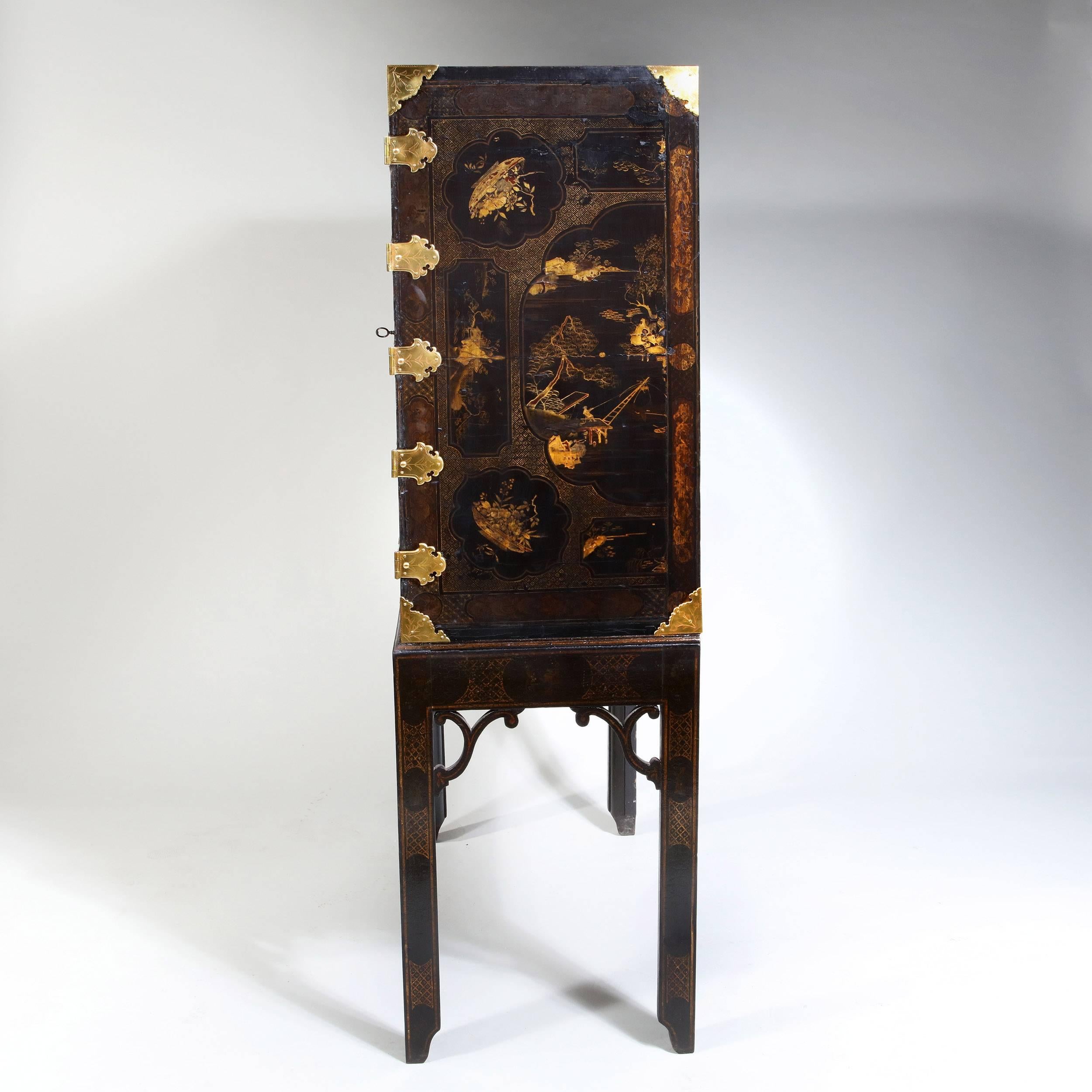 A George III chinoiserie cabinet on stand made using panels of 17th century Japanese lacquer and formed in the traditional manner. Standing on its original japanned Stand, throughout the lacquer is worn but in good condition,

England, circa 1780.