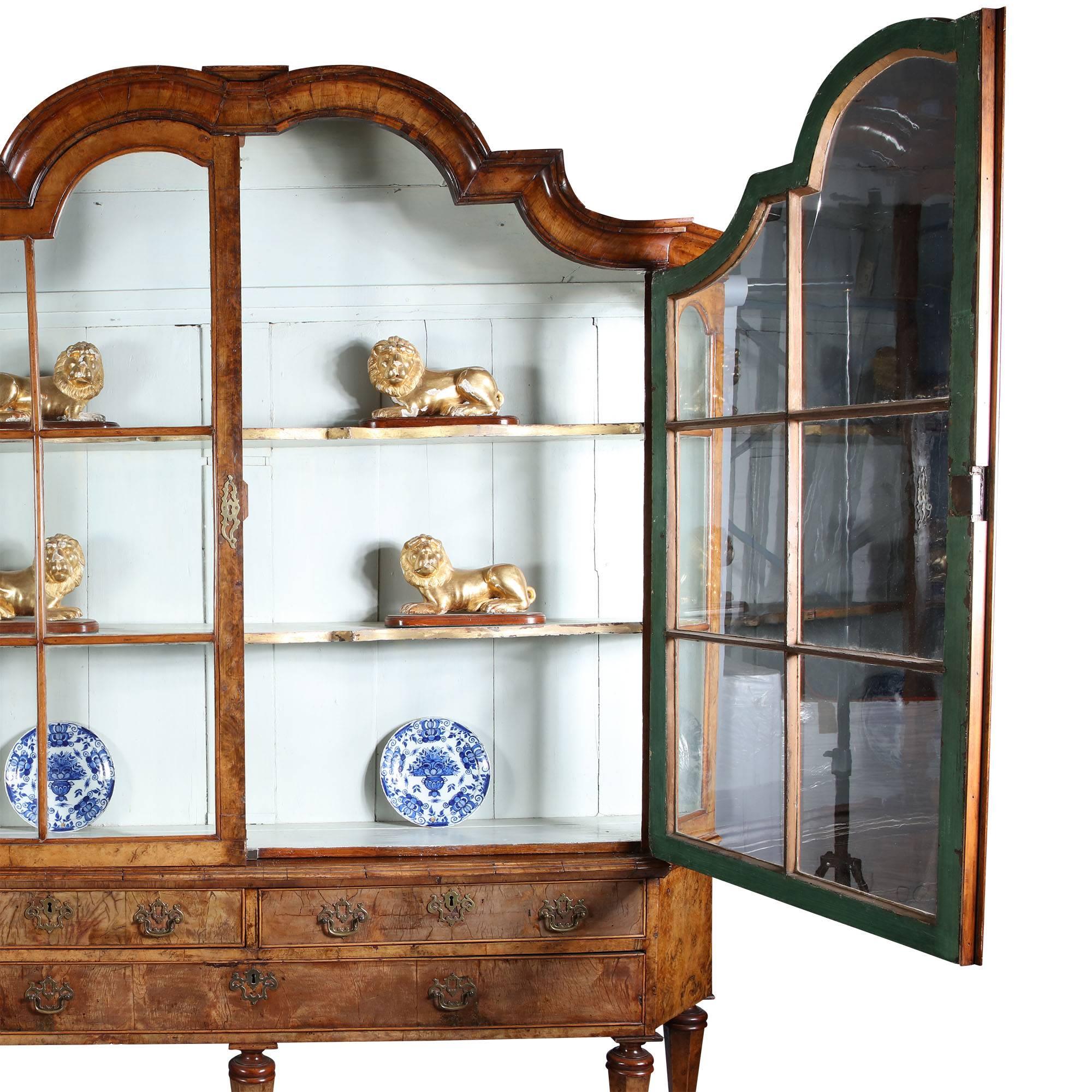 Wonderful rich early 18th century Dutch highly figured burr walnut glazed display cabinet. 

The upper section glazed with two shelves and the lower with drawers above column legs joined by a serpentine shaped stretcher.

All the shelves original,