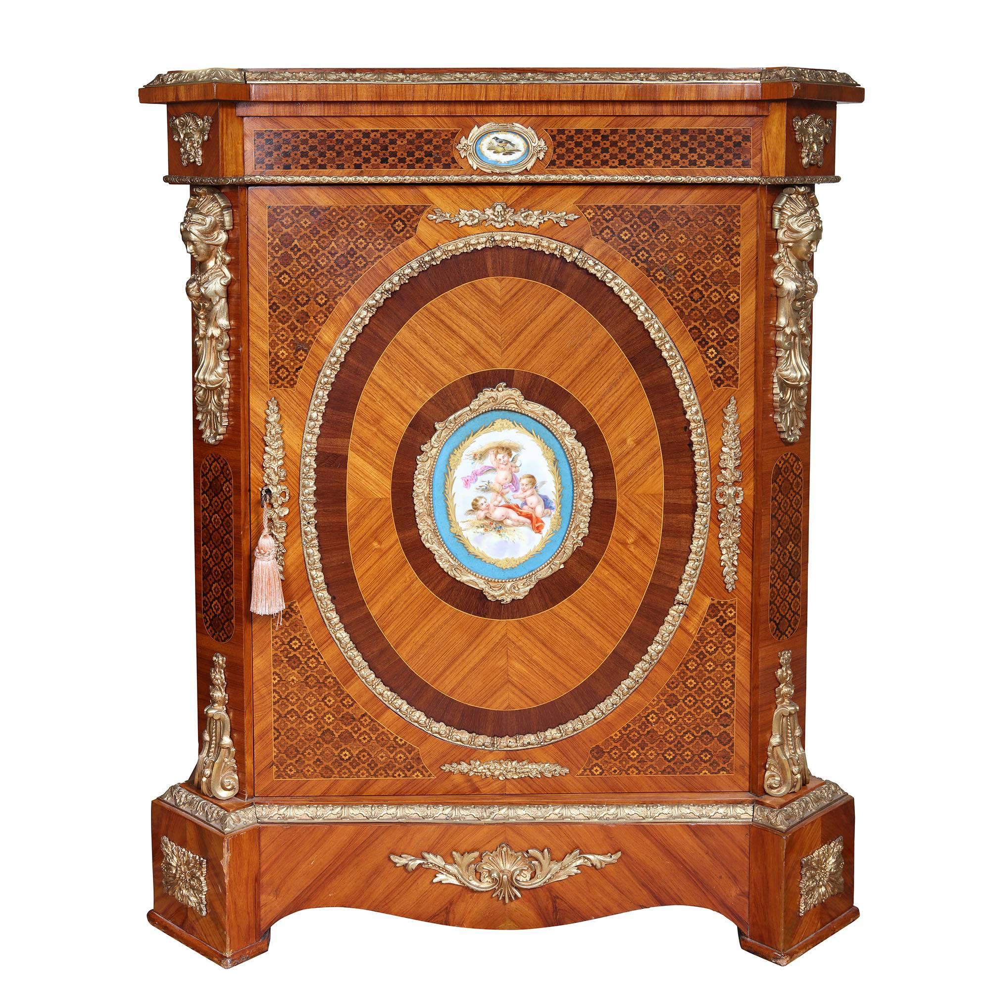 A fine 19th century Napoleon III side cabinet with inlaid marquetry panels, book matched sides with gilt bronze mounts of classical figures and foliage. The top drawer and central panel with sevres porcelain panels with marquetry borders. Opening to