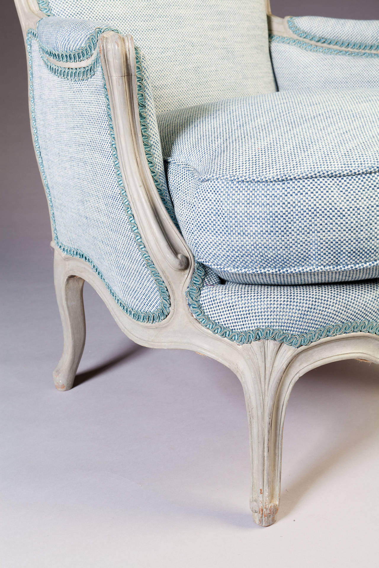 These fabulous bergeres are an unusually large and generous scale. The bergeres with reclined backs of simple outline with channeled detailing, outswept arms of Rococo inspiration raised on cabriole legs with neoclassical fluting.

Newly