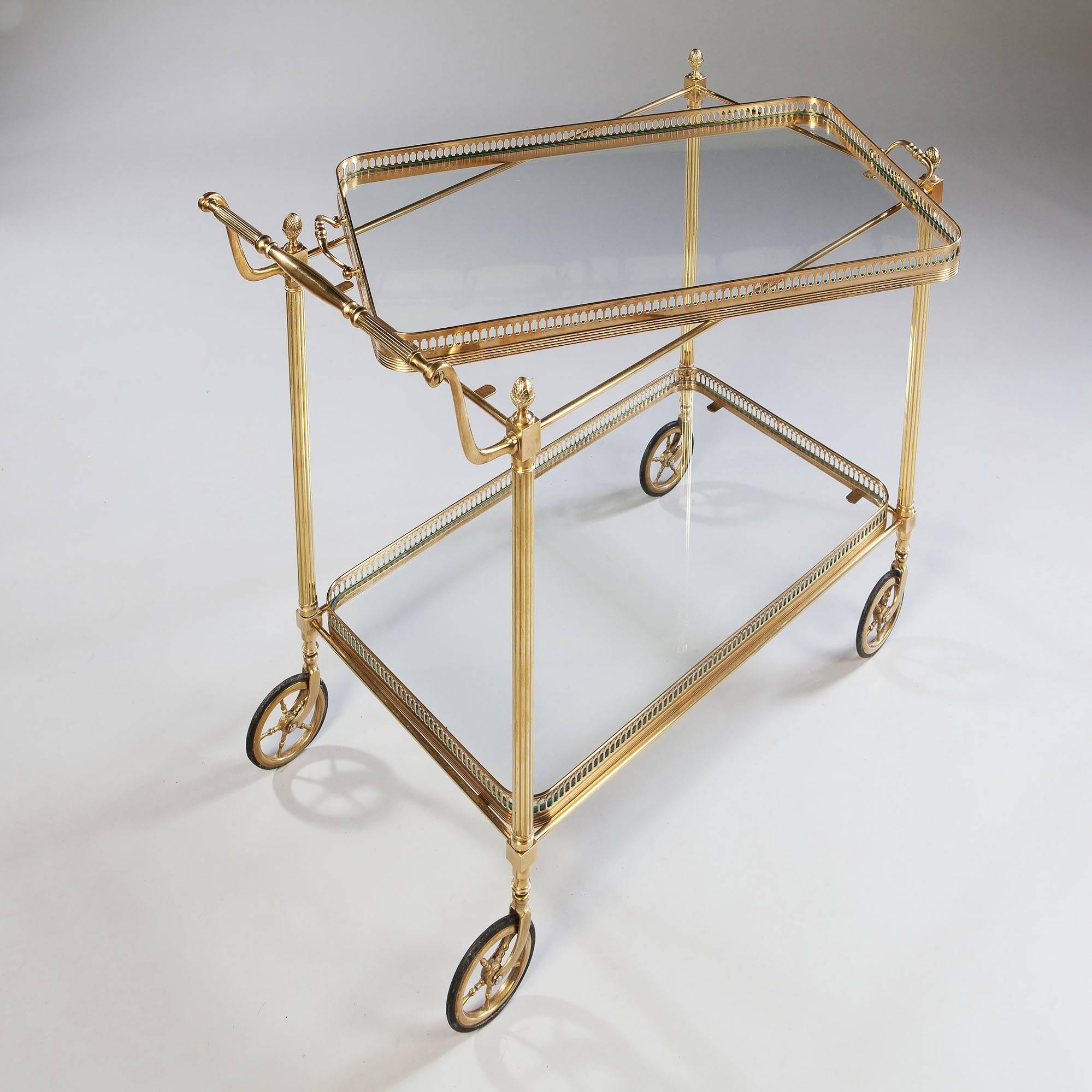 A fine polished brass drinks trolley by Maison Bagues, the trolley with two tiers and removable glass bottomed trays with pierced brass galleries, the upper tray with handles. The brass casting and detail throughout of high quality and condition.