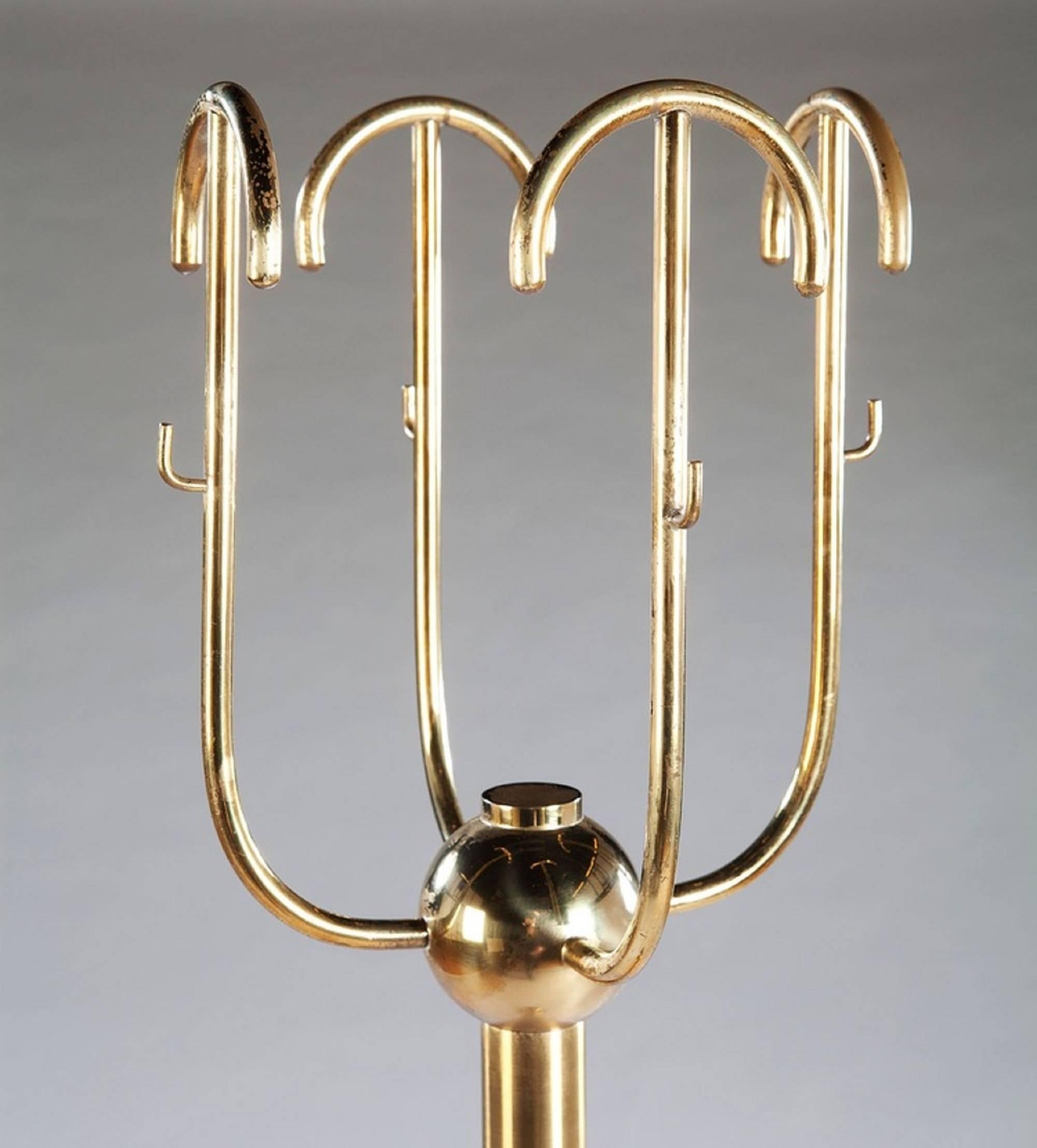 An Italian 1980s brass hat and coat stand of unusual form. Having a revolving top and marble weighted base,

Italy, circa 1985

Measures: Height 63in, 
diameter of base 14in.