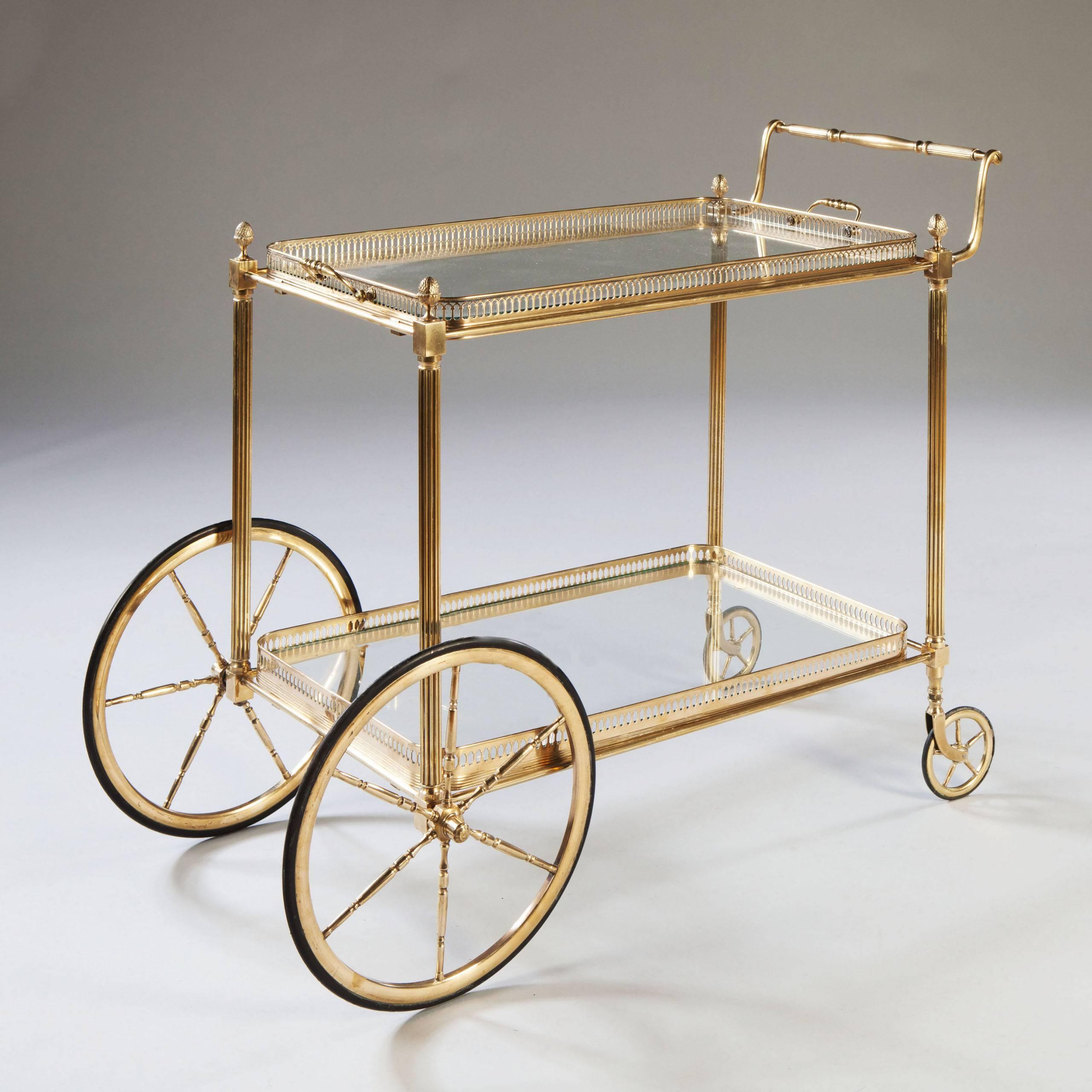 A fine quality mid-20th century polished brass and glass two tier drinks trolley by Maison Jansen.

​Both trays removable and the upper one with handles. This trolley with larger wheels at the front. 

Bar cart.
Cocktail table. 
Champagne