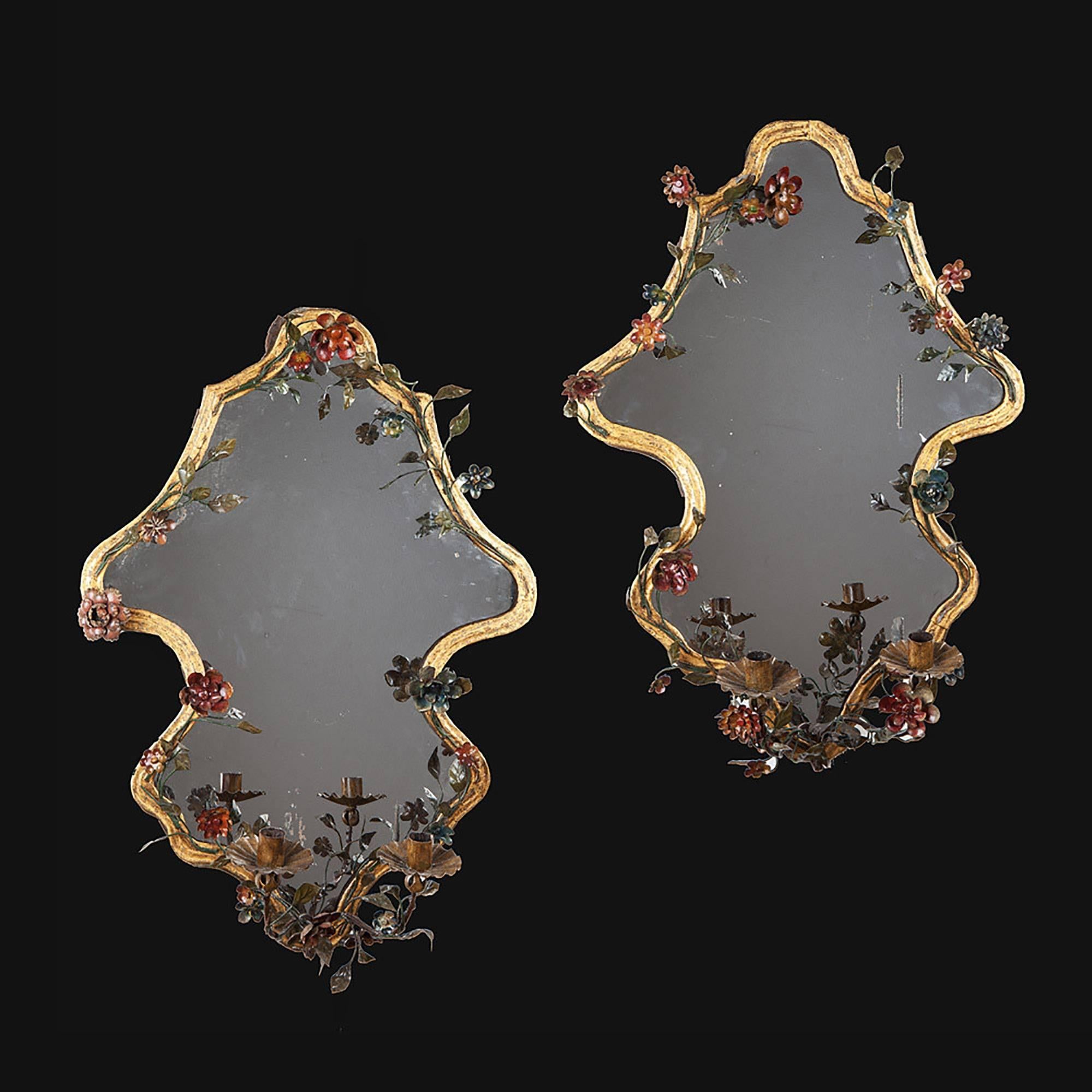 Northern Italy, circa 1840.

​A pair of Piedmontese elaborately shaped tôle girandoles with gilt borders mounted with polychrome flowers. Each retains its original two branch candle arms. 

Measures: Height 27.5 in (70 cm), width 20 in (51 cm).