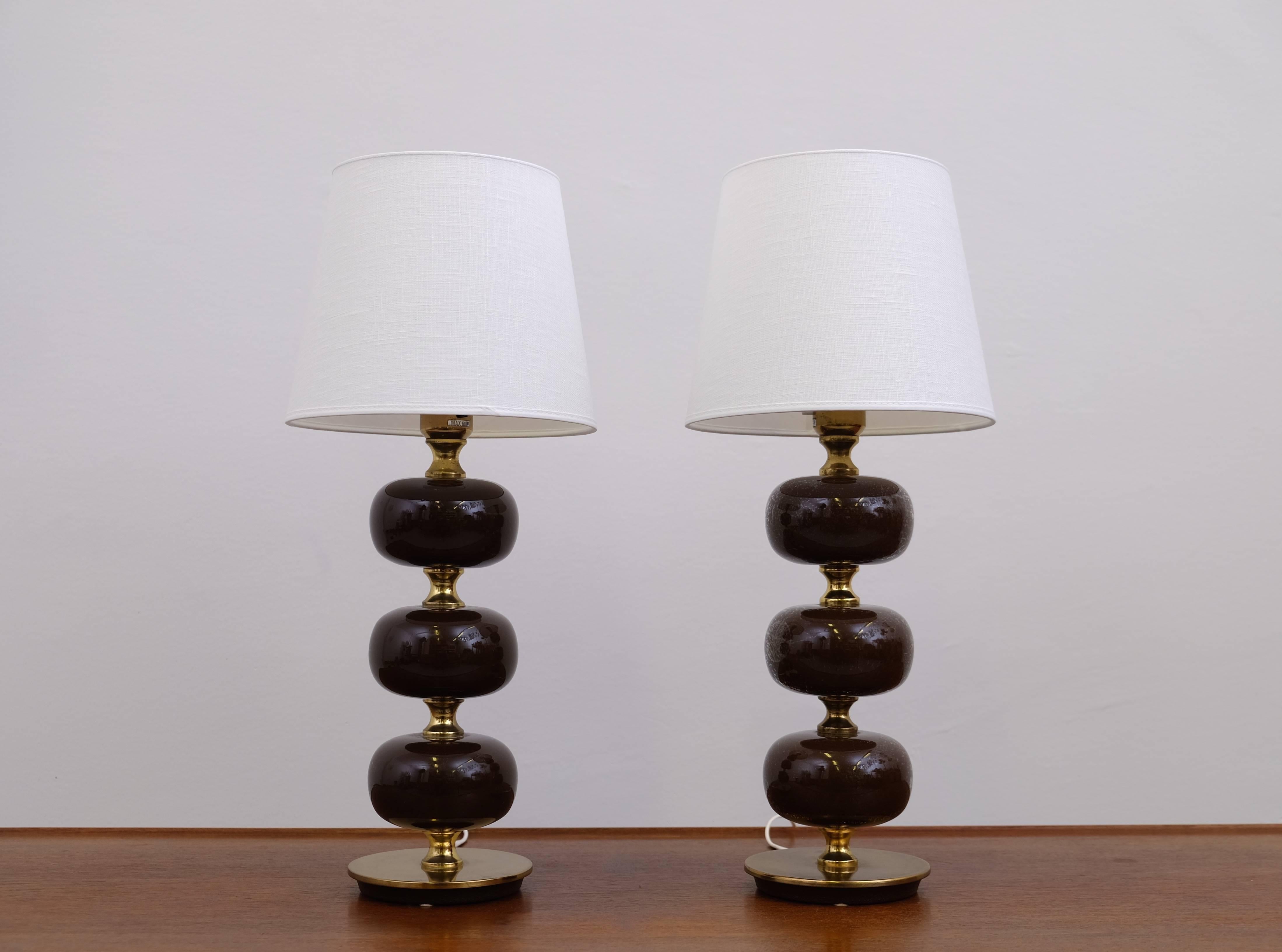 Pair of Swedish table lamps by Stilarmatur Trana°s in brass with three spheres in brown glass. Stamped.