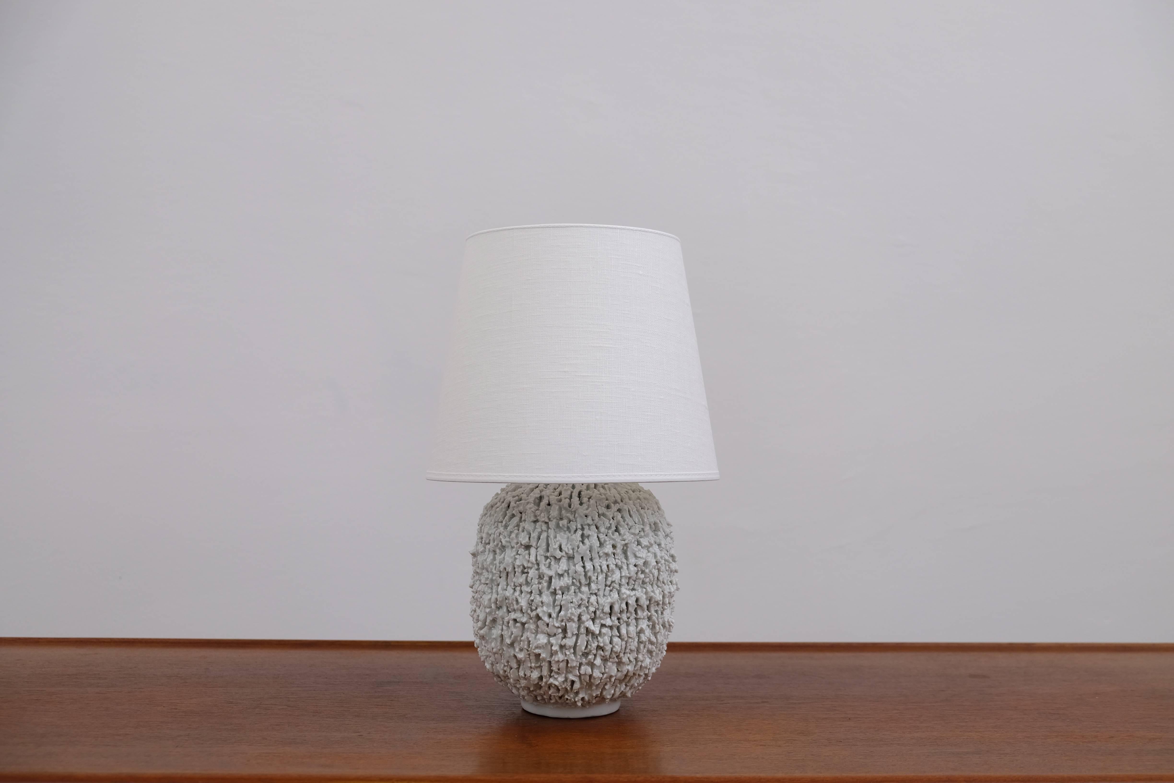 Ceramic lamp in bulbous shape by Gunnar Nylund, composed of chamotte clay and glazed with a white colored luster glaze. Produced by Rörstrand. Stamped.