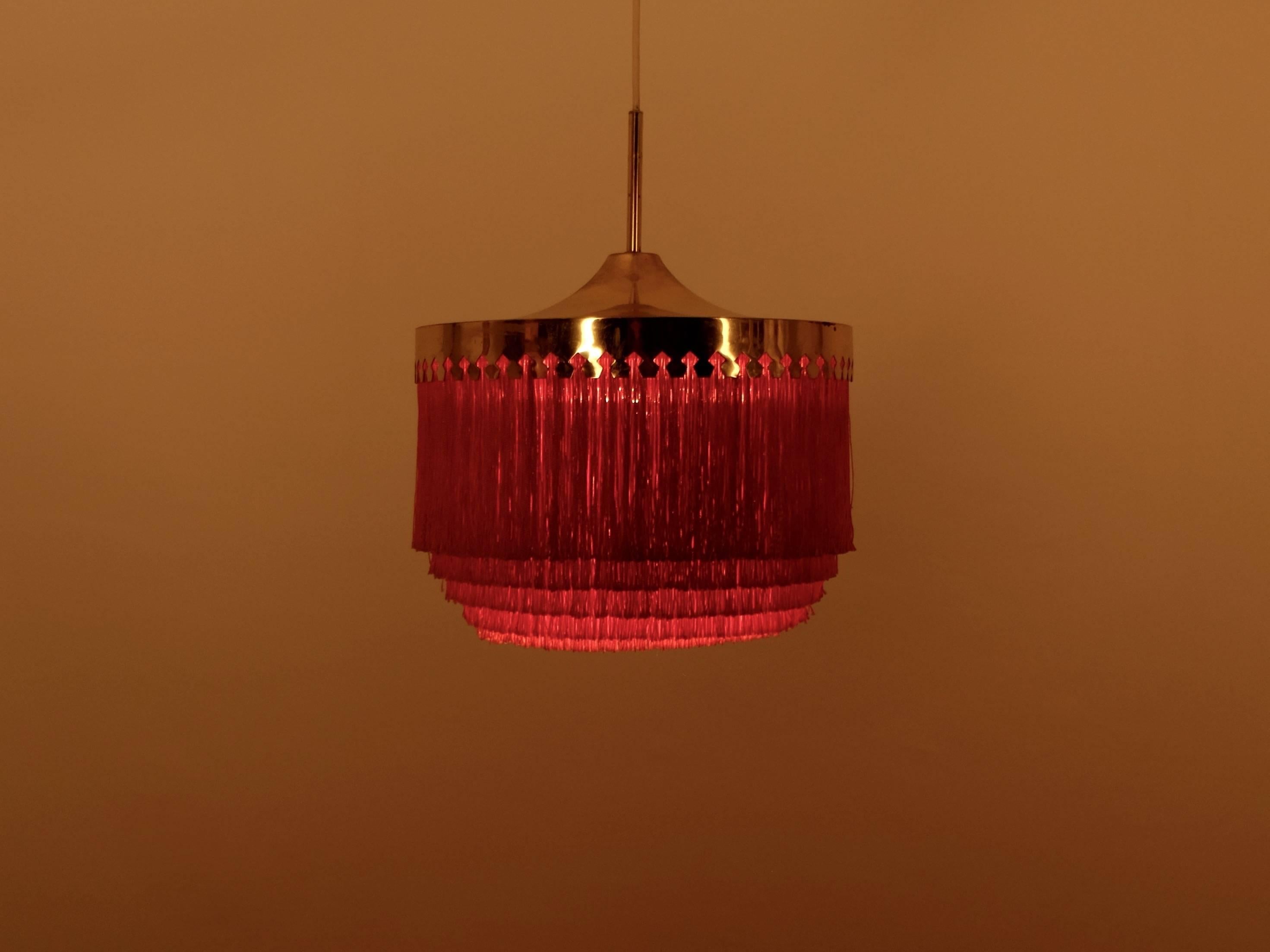 Orange fringes and patinated brass.
Produced by Hans-Agne Jakobsson, Markaryd, Sweden, 1960s.
Height is adjustable.