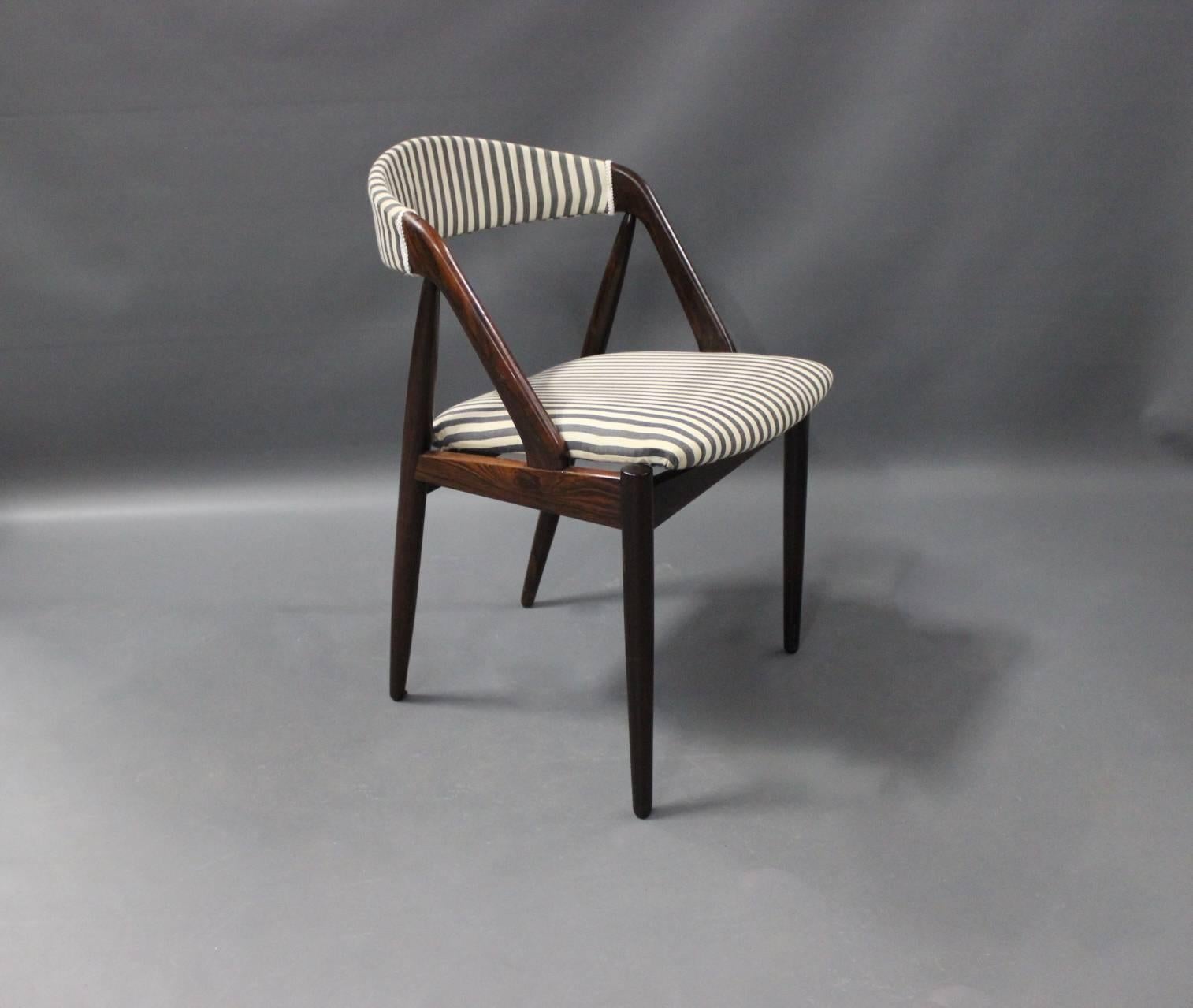 A set of six dining room chairs, model 31, designed by Kai Kristiansen in 1956 and manufactured by Schou Andersen in the 1960s. The chairs are in Brazilian rosewood and upholstered in stribed fabric.
