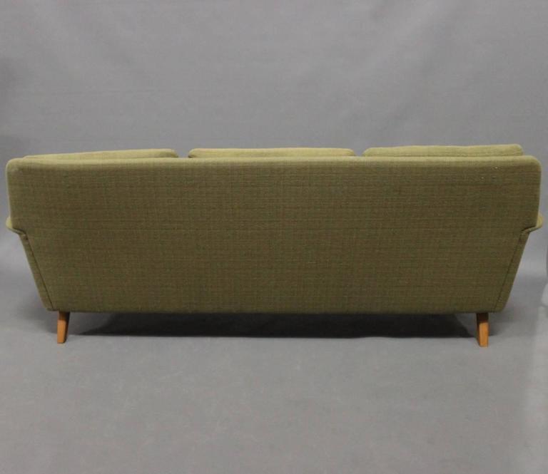 Three-seat DUX sofa designed by Folke Ohlsson and manufactured by Fritz Hansen in the 1960s. The sofa is upholstered in green wool fabric.