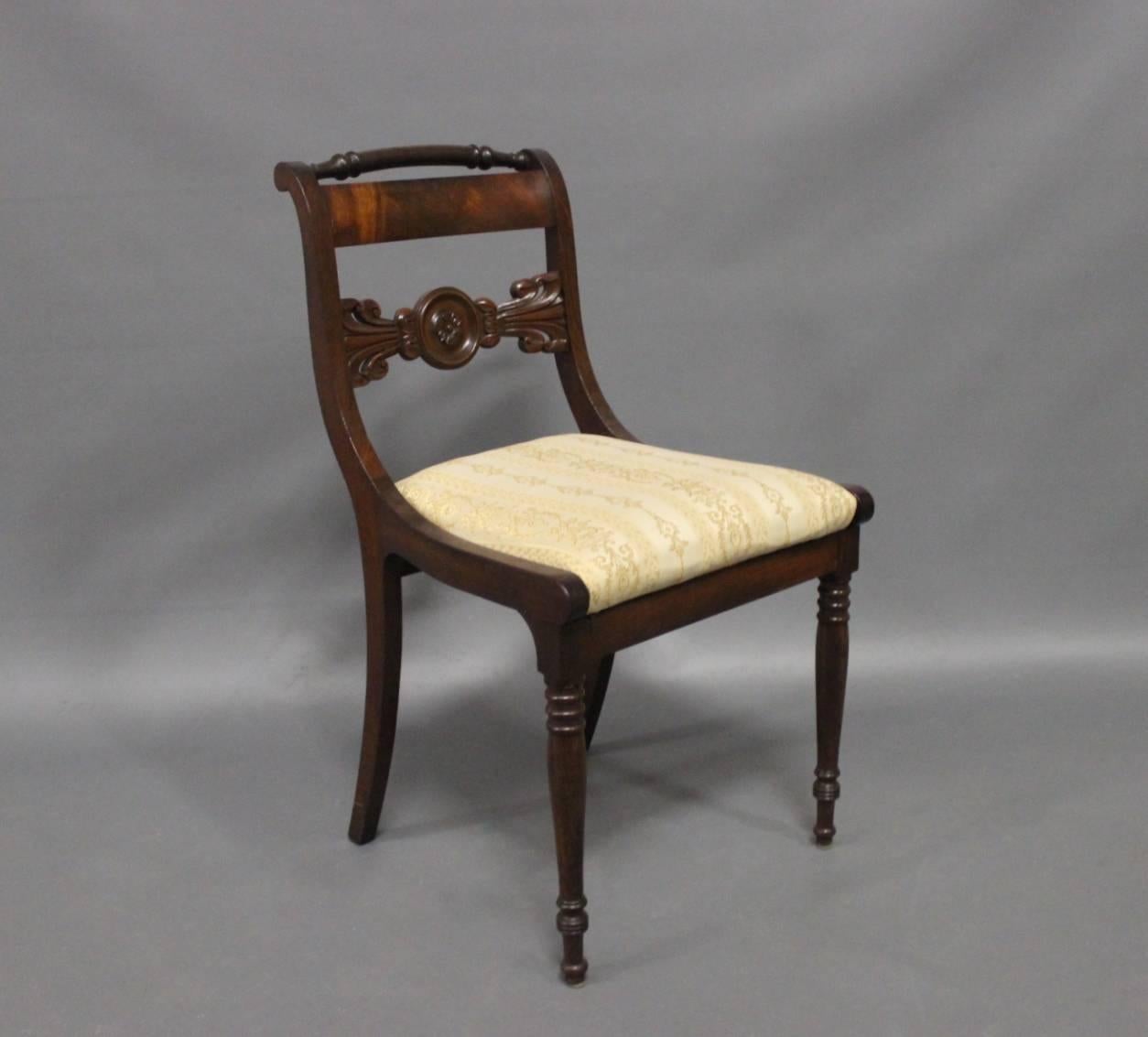 A set of nine antique chairs in the style of late Empire from circa 1840. The chairs are of hand polished mahogany and with seats of light fabric.