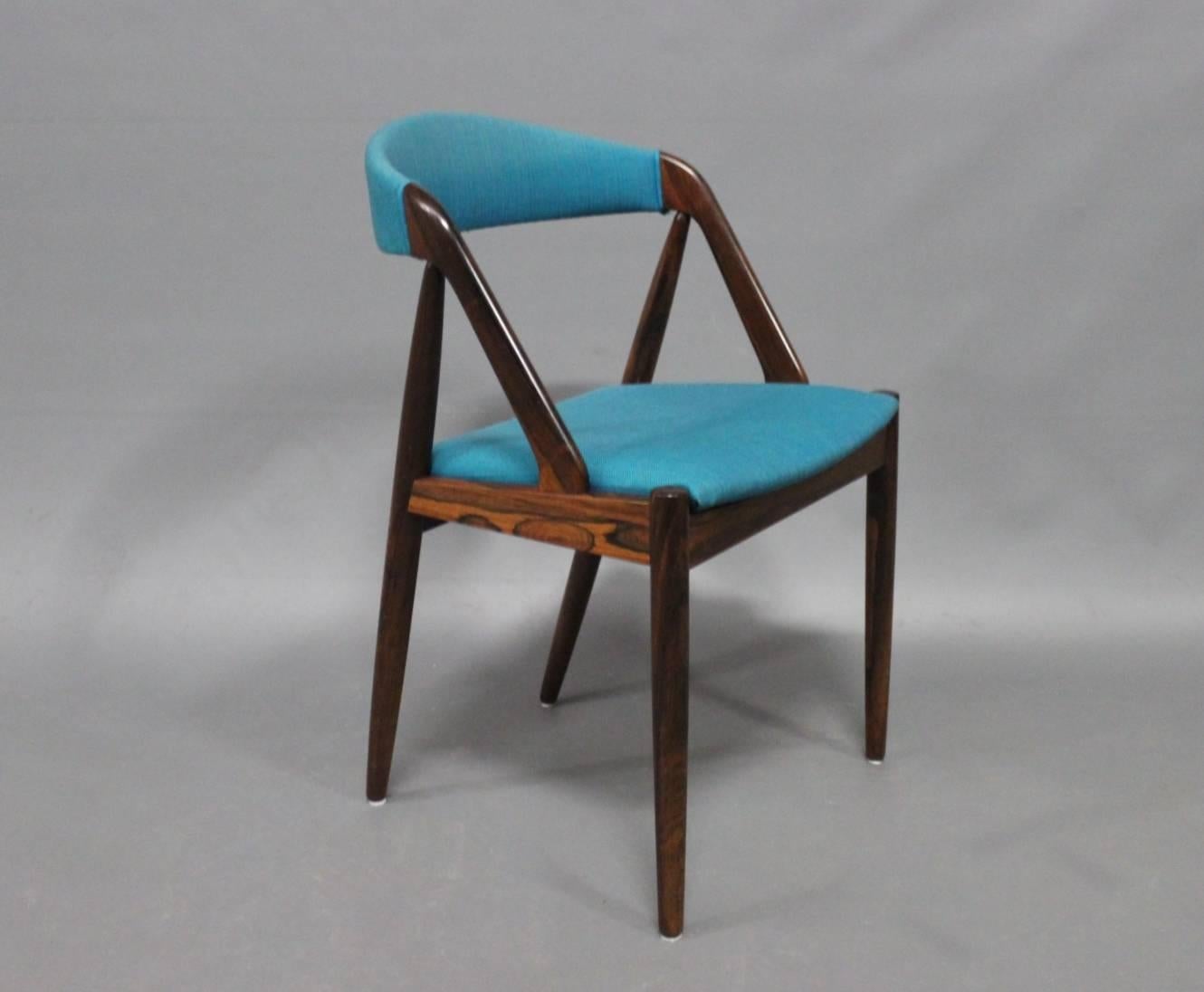 A set of six dining room chairs, model 31, designed by Kai Kristiansen in 1956 and manufactured by Schou Andersen in the 1960s. The chairs are in rosewood and upholstered in blue fabric.