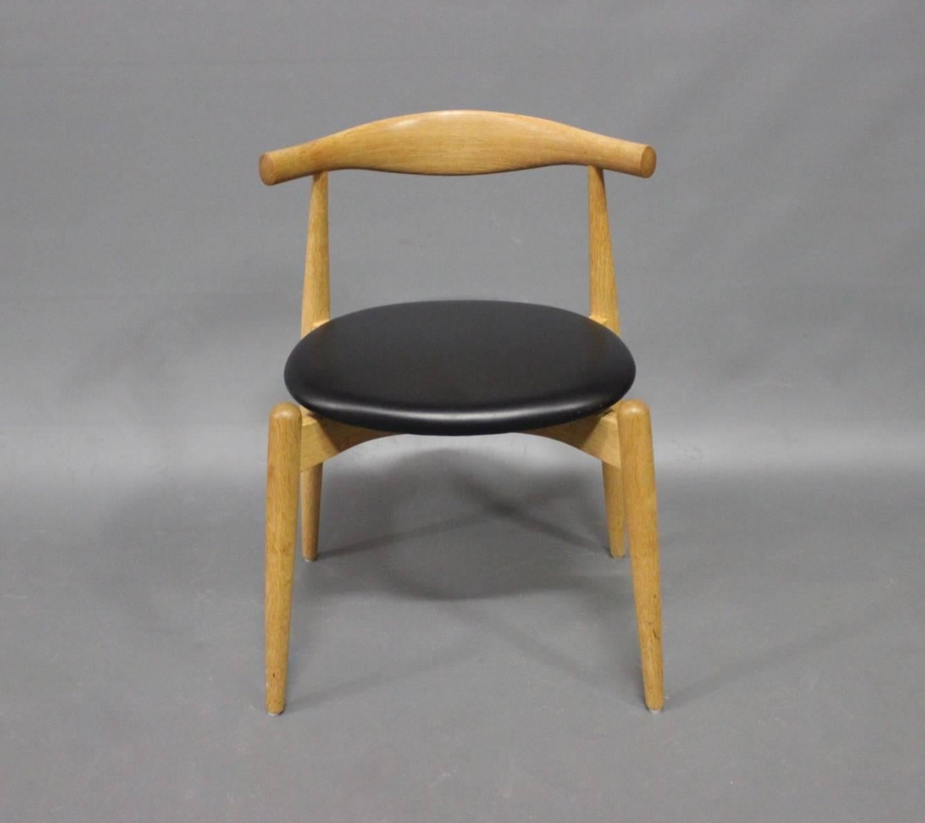 A set of six, Elbow chairs, CH20, designed by Hans J. Wegner in 1956 and manufactured by Carl Hansen & Son in 2008. The chairs are of oak and with seats of black leather.