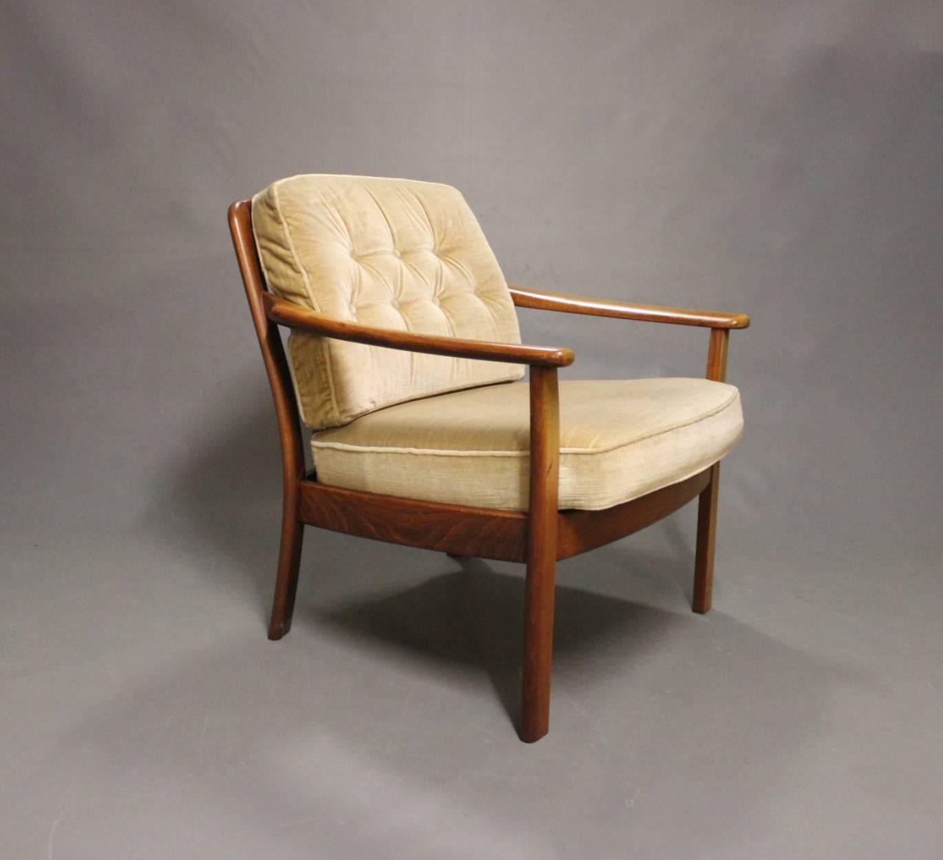 A pair of easy chairs in polished wood and seats in velvet of Danish design from the 1960s. The chairs are in great vintage condition.