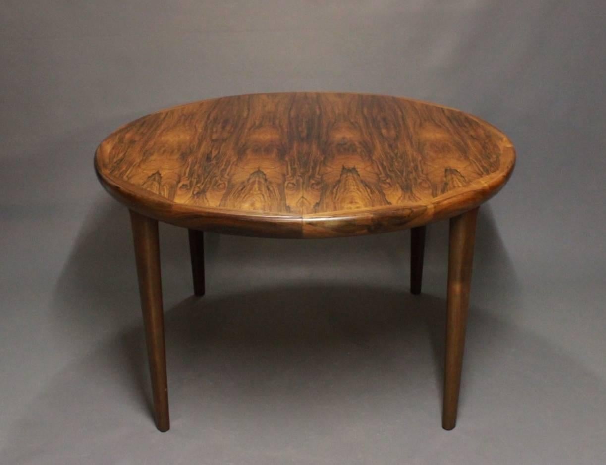 Dining room table in rosewood designed by Arne Vodder and from the 1960s. The table has two extension leaves and be colored in to match the table.
   