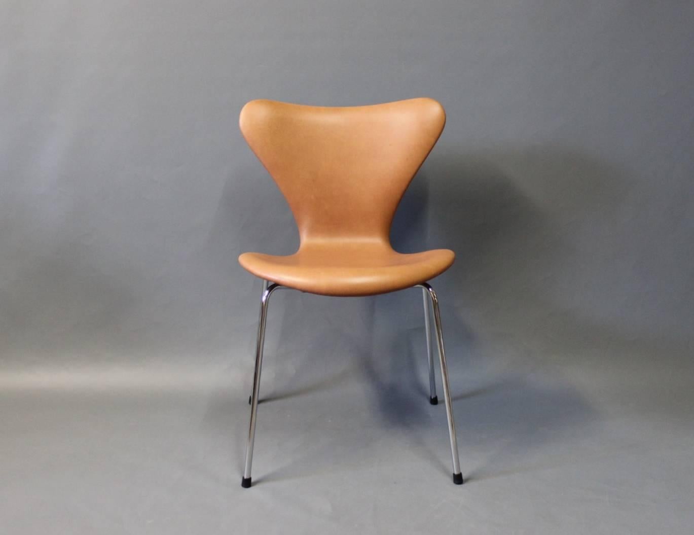 A set of four seven chairs designed by Arne Jacobsen in 1955 and manufactured by Fritz Hansen in 1967. The chairs have recently been upholstered with cognac colored elegance leather.