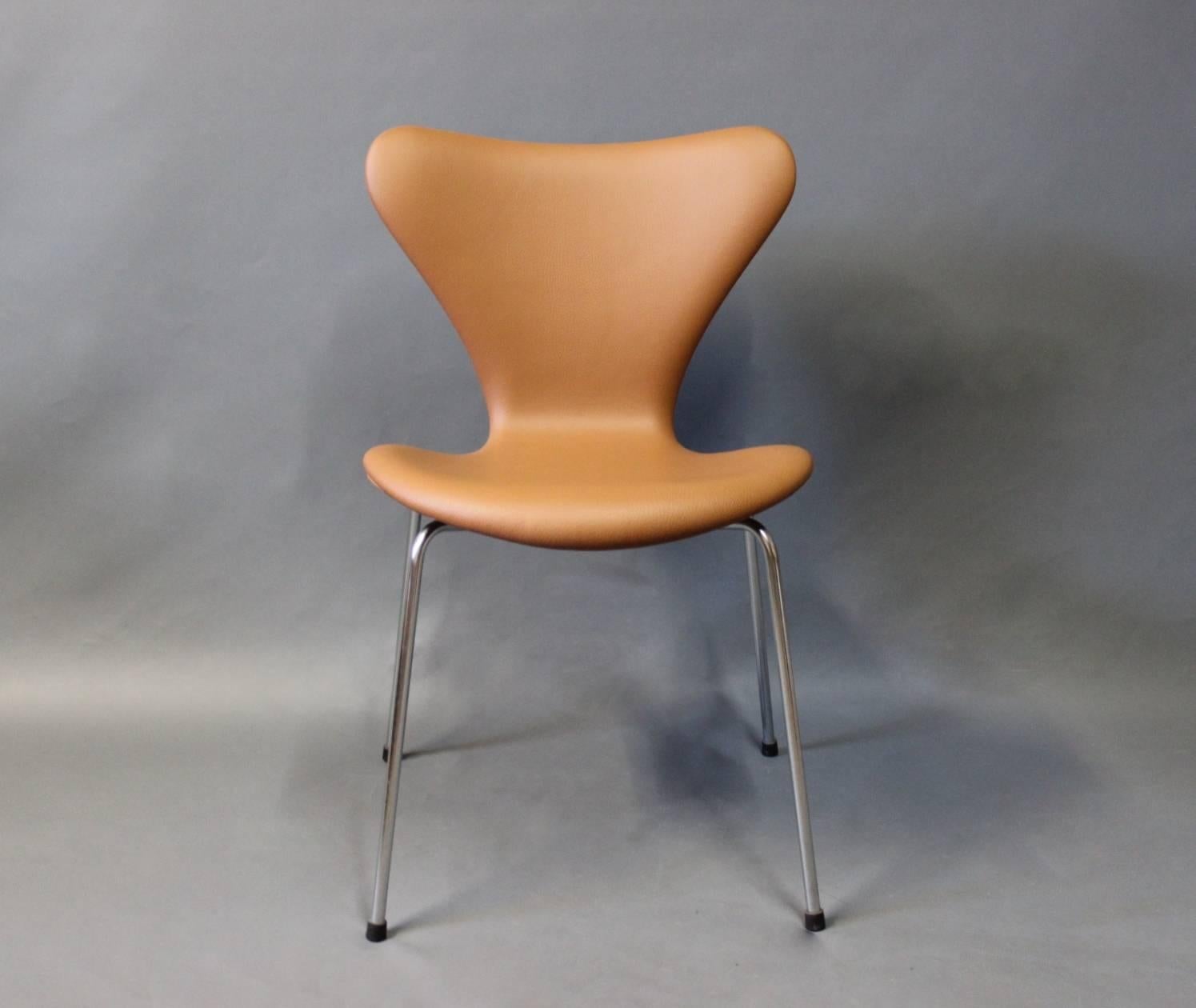 A set of four seven chairs designed by Arne Jacobsen in 1955 and manufactured by Fritz Hansen in 1967. The chairs have recently been upholstered with cognac colored Classic leather.