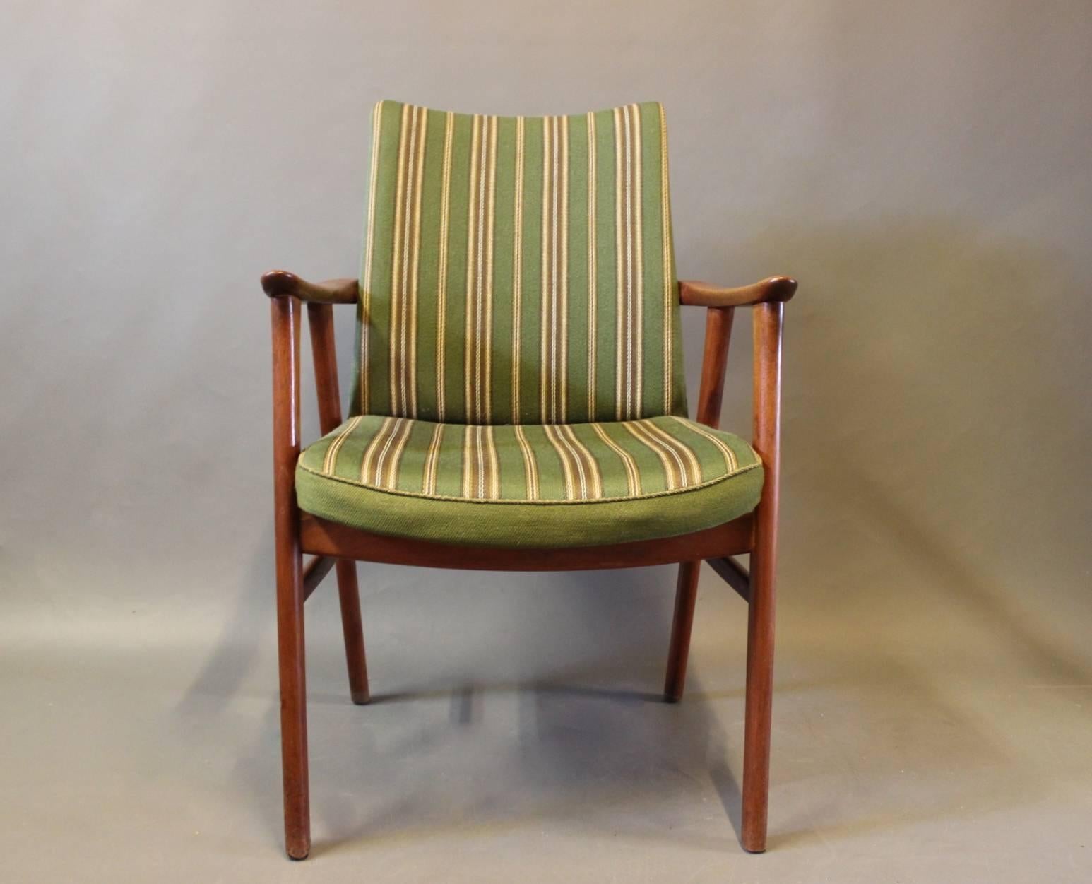 Armchair in teak and upholstered in green fabric of Danish design from the 1960s. The chair is in great vintage condition.