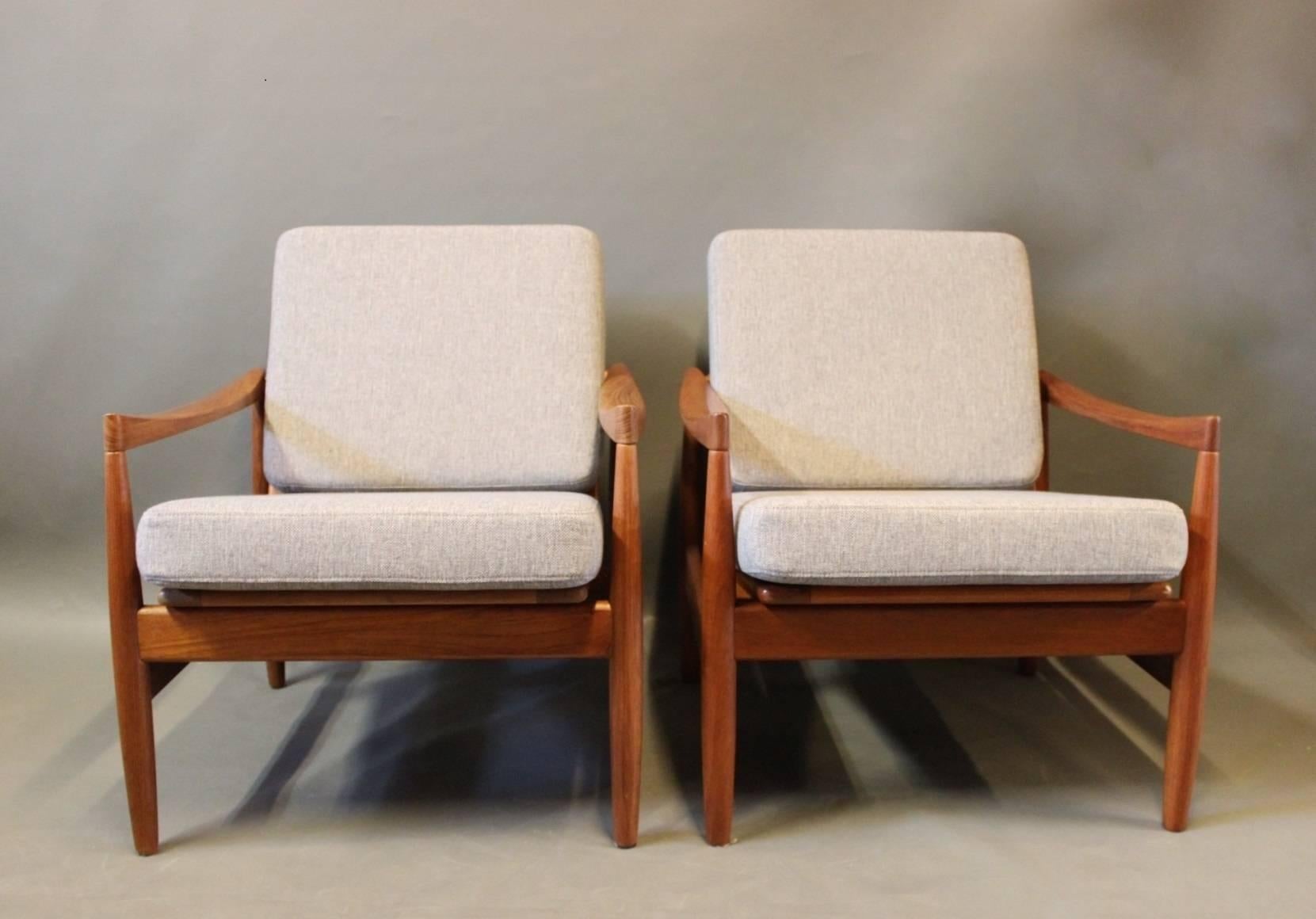 A pair of easy chairs in teak and cushions of light grey wool designed by Kai Kristiansen and manufactured by Skive Møbelfabrik. The chairs are from the 1960s and the cushions are newly upholstered.