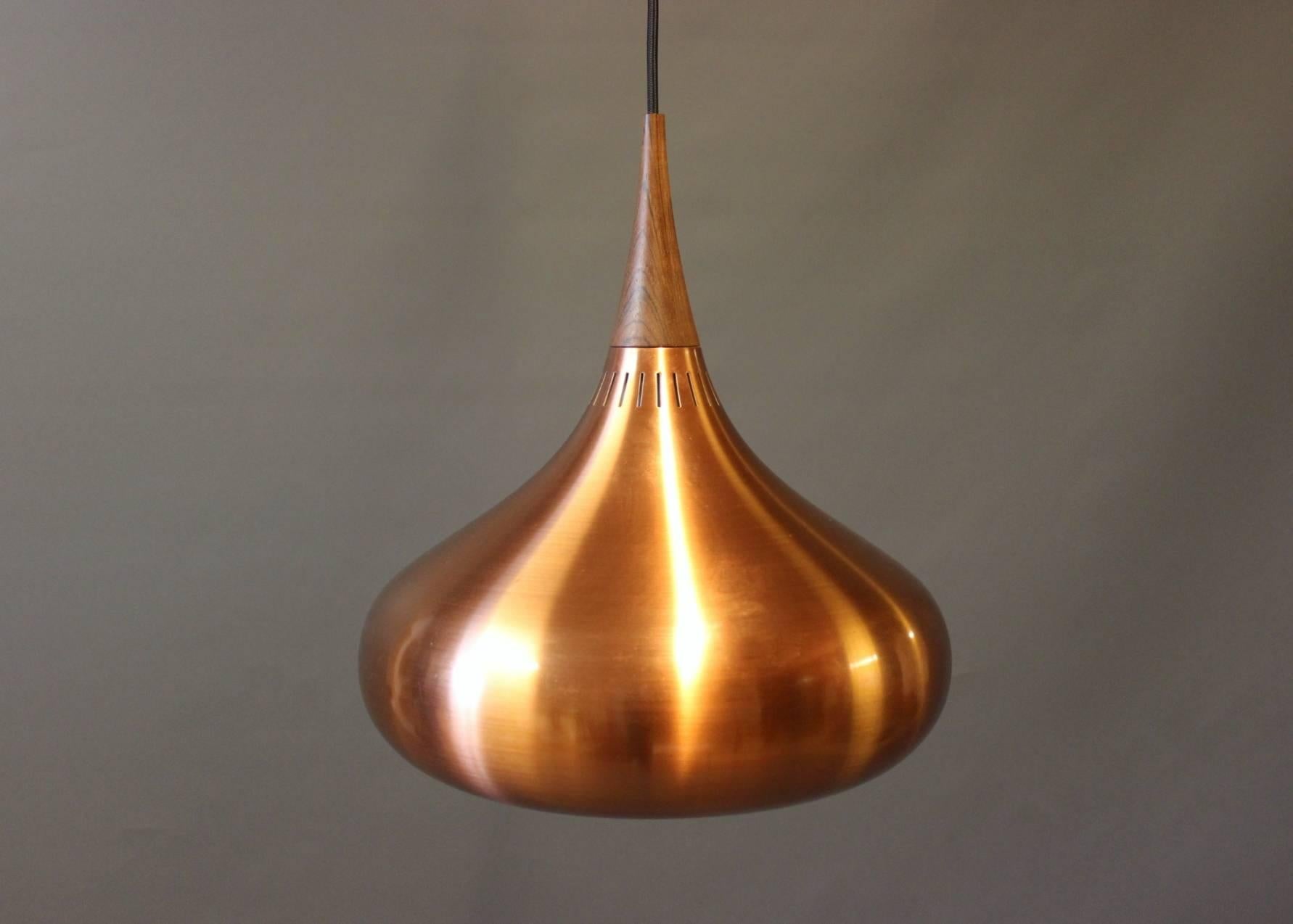 A pair of "Orient" pendants, model P1 and P2, designed by Jo Hammerborg for Fog & Mørup in the 1960s. The lamps are of brushed copper and rosewood.