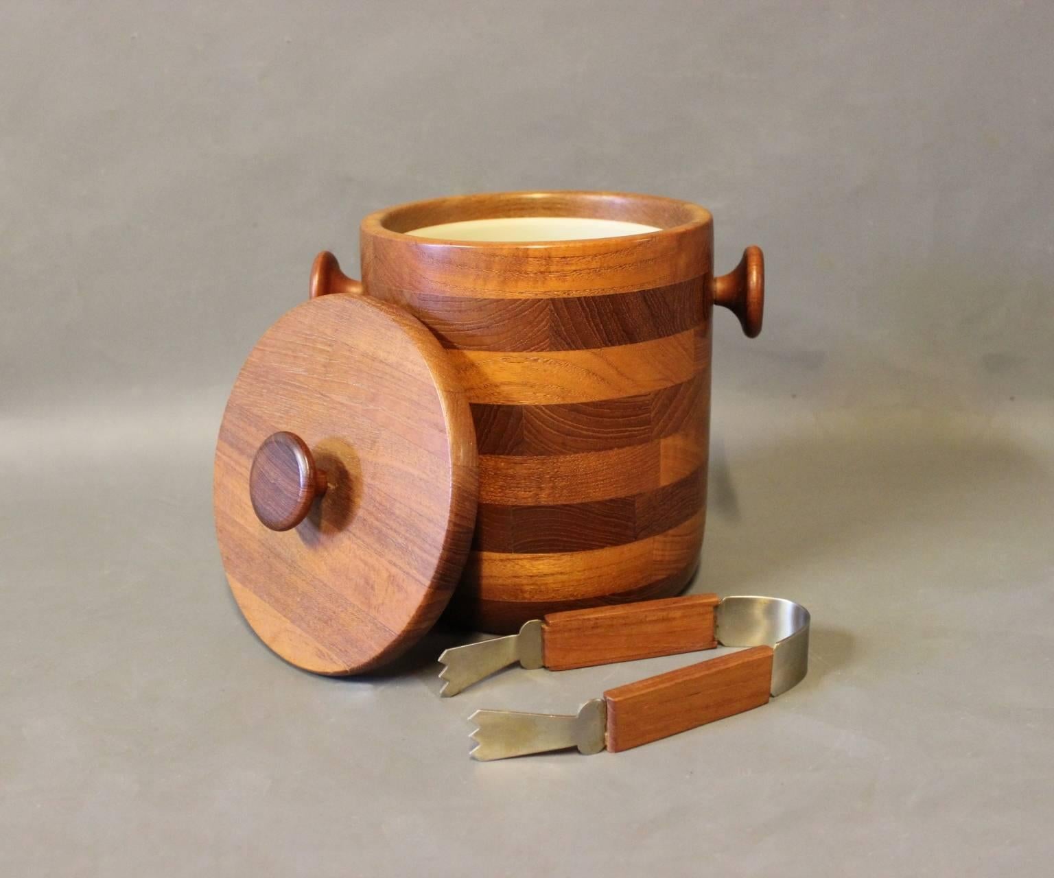 Ice bucket in teak with matching tongs. The item is of danish design from the 1960s.