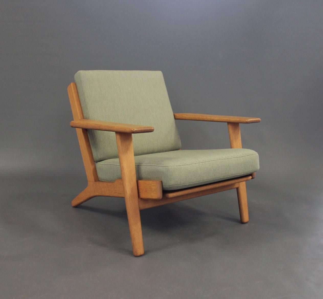 Armchair, model GE290 and matching stool, designed by Hans J. Wegner in the 1950s and manufactured by GETAMA in the 1960s. The chair and stool are of oak and with cushions of light green Hallingdal wool.