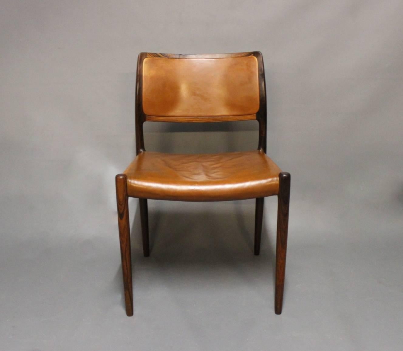 Set of four dining chairs, model 80 in rosewood and cognac colored leather designed by N.O. Møller and manufactured by J. L. Møller furniture factory in the 1960s.